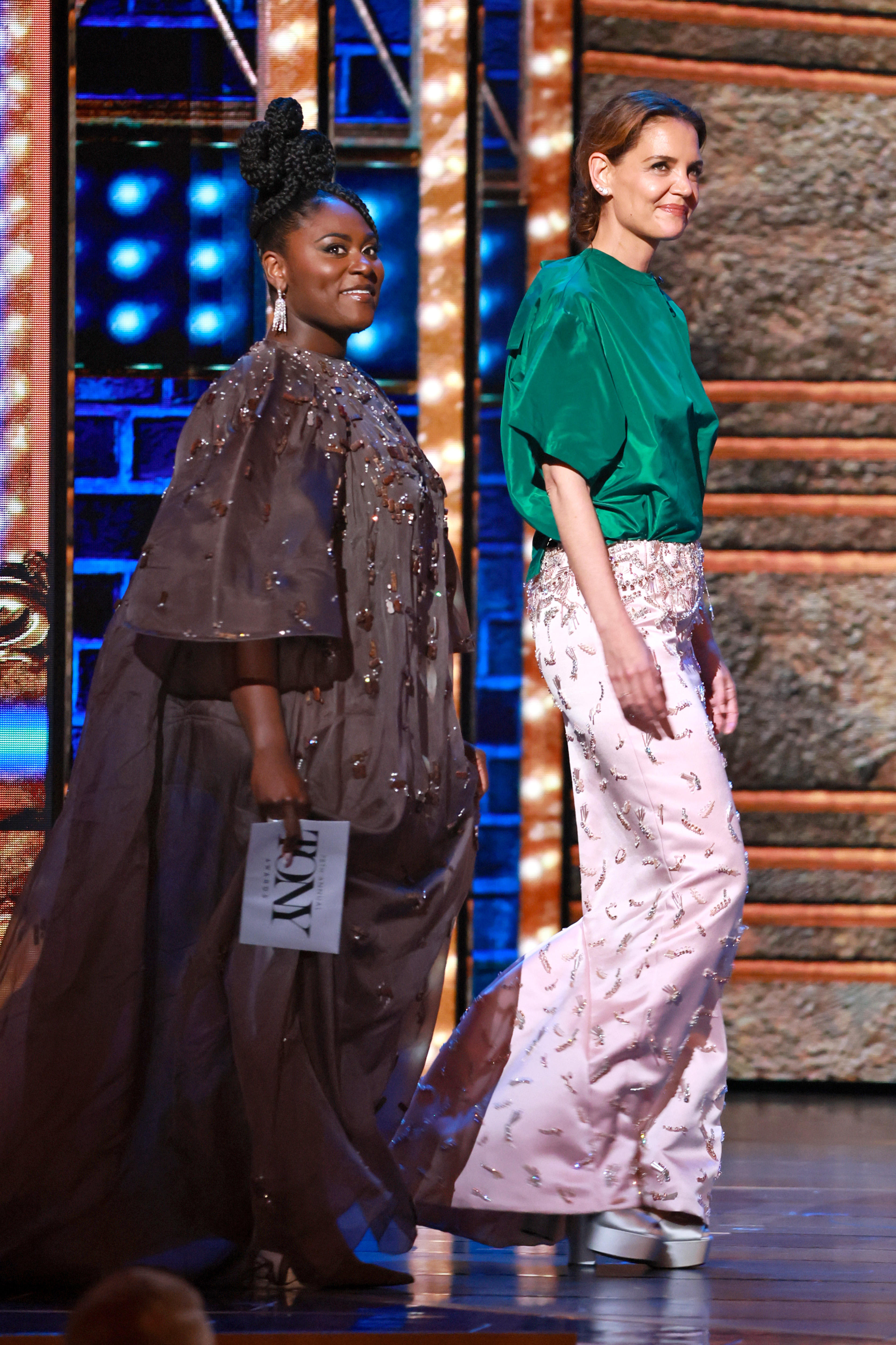 Katie Holmes walks onstage alongside Danielle Brooks, presenting with poise and a soft smile. Their confident entrance drew attention as they shared a spotlight moment in front of the live audience.