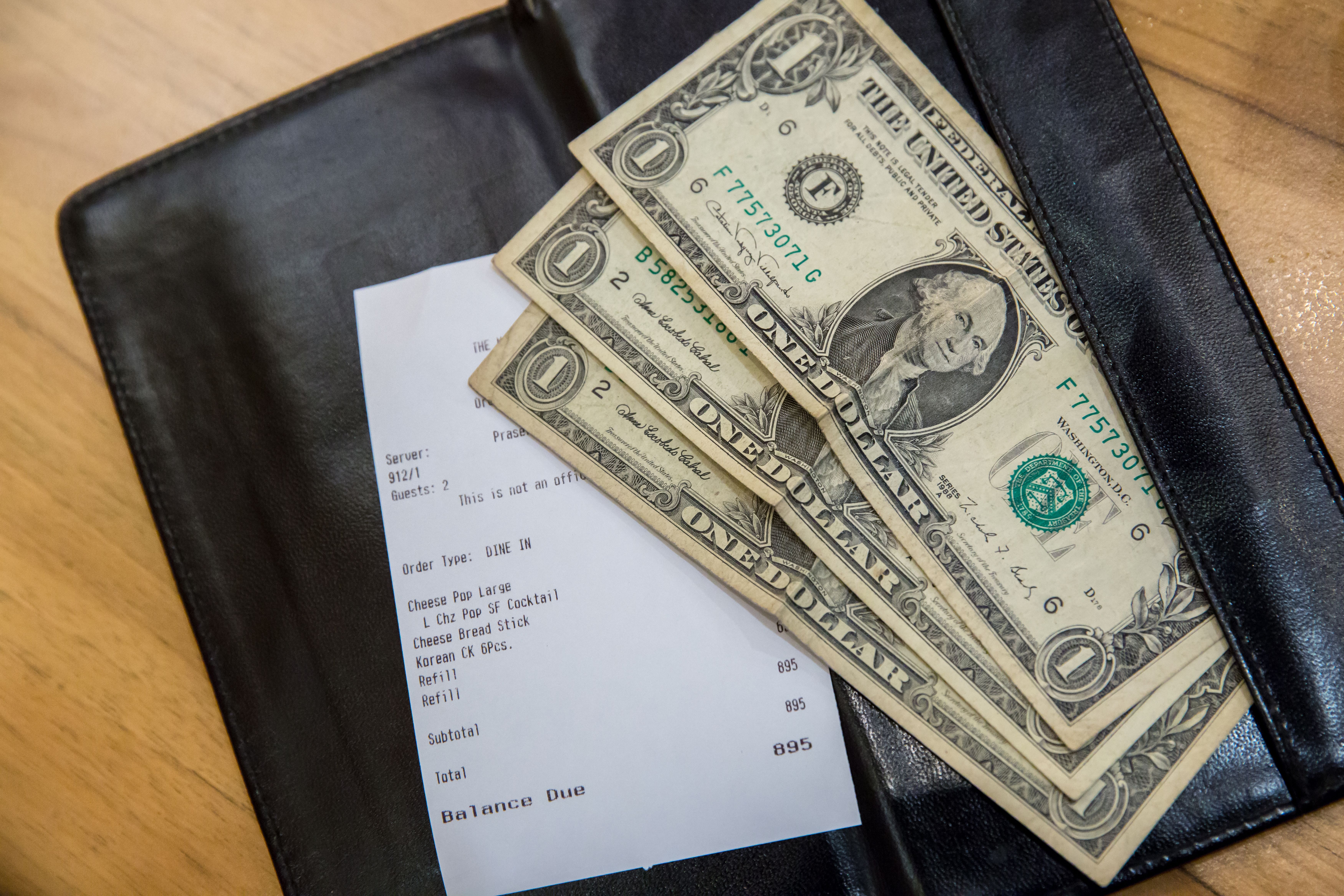 Dollar bills placed on a check. | Source: Shutterstock