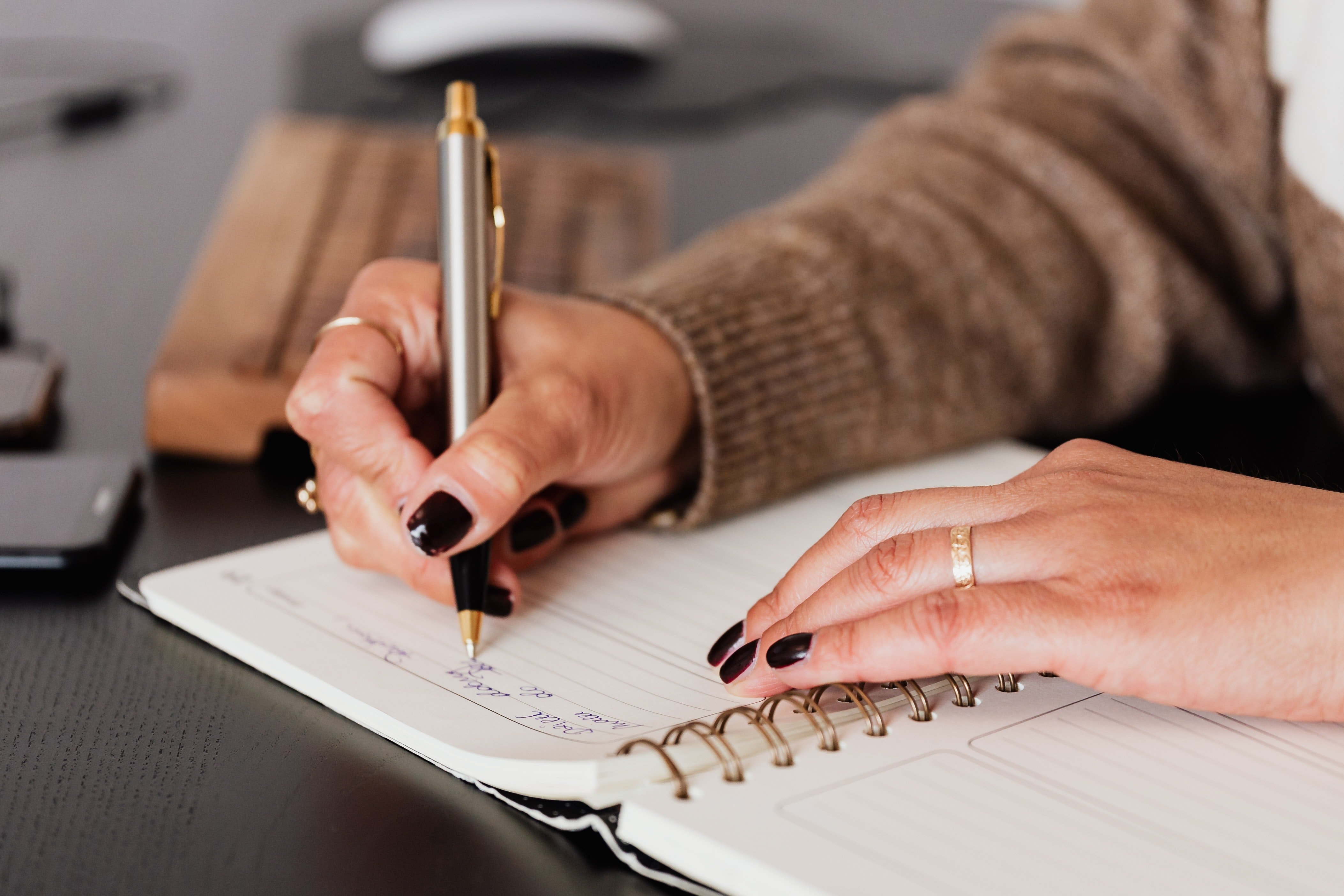 Mujer escribiendo en una libreta. | Foto: Pexels