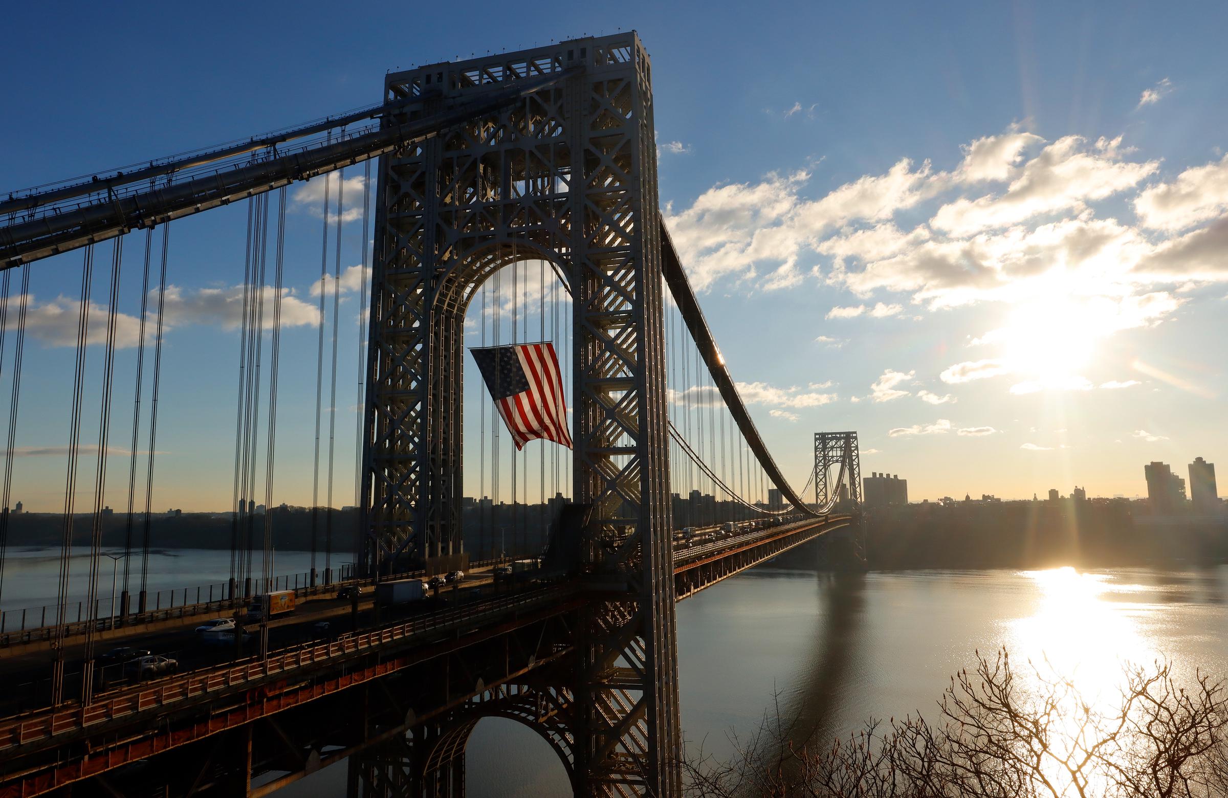 Vehicles cross the George Washington Bridge as an American flag flies at sunrise for Presidents Day on February 19, 2024. | Source: Getty Images