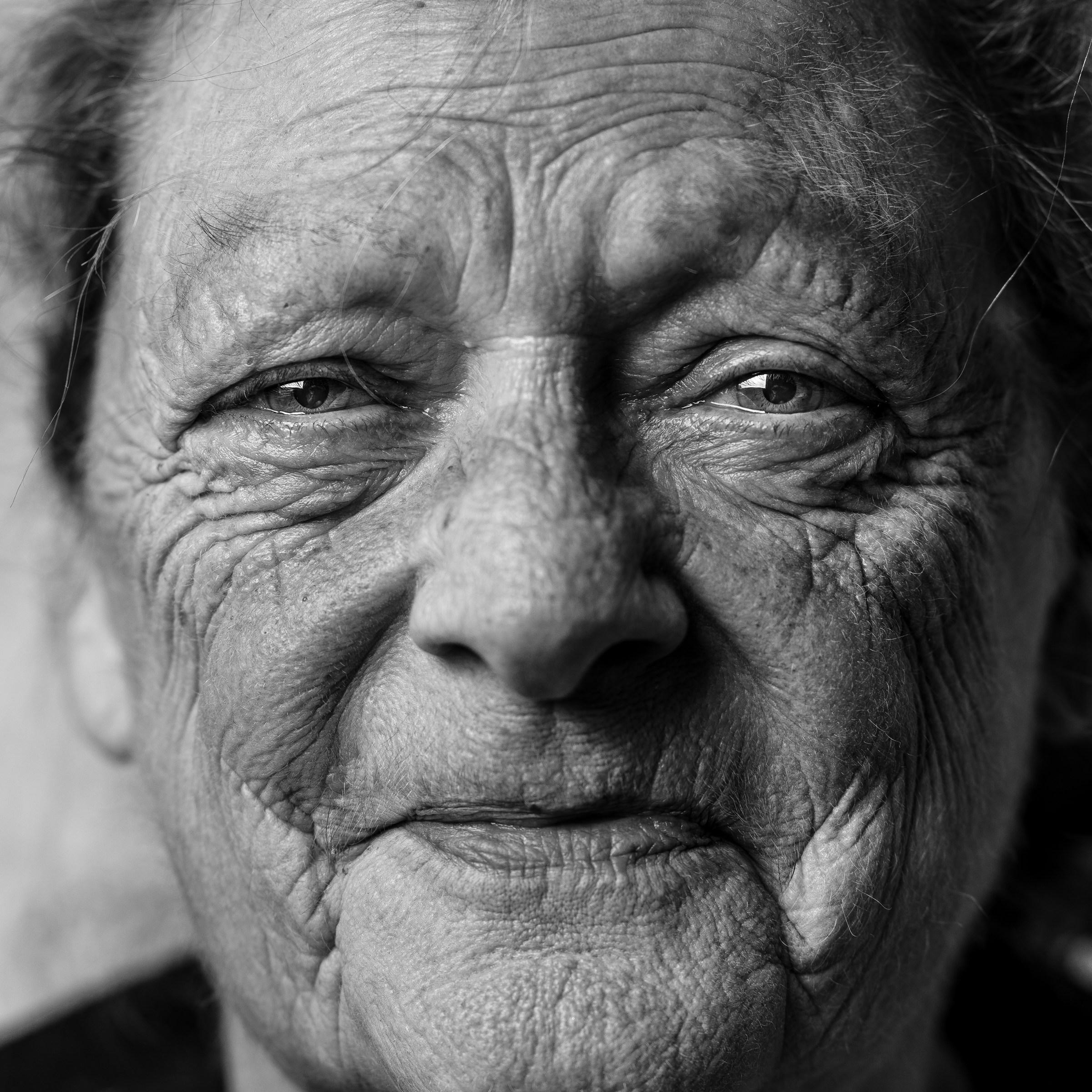 A grayscale photo of a smiling senior woman | Source: Unsplash