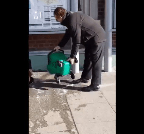 Trabajador vertiendo agua sucia sobre hombre. | Imagen: Twitter / Metro UK Trabajador vertiendo agua sucia sobre hombre. | Imagen: Twitter / Metro UK