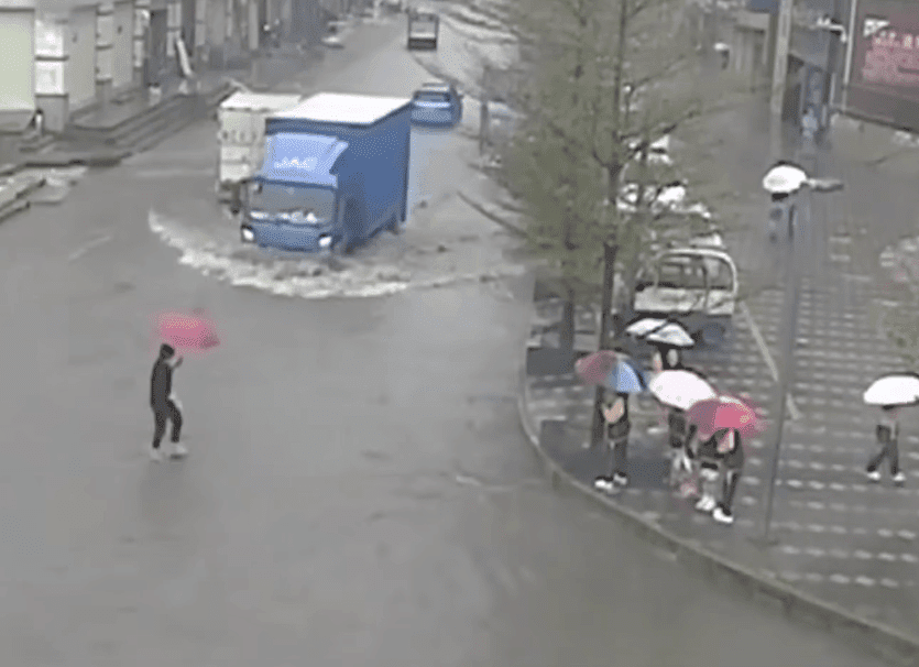 Maestra cargando a sus alumnos sobre una calle inundada en China. | Imagen: YouTube/Daily Mail Maestra cargando a sus alumnos sobre una calle inundada en China. | Imagen: YouTube/Daily Mail