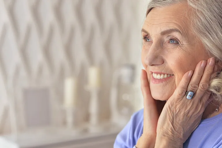 Portrait d'une personne âgée se touchant le visage | Photo : Shutterstock