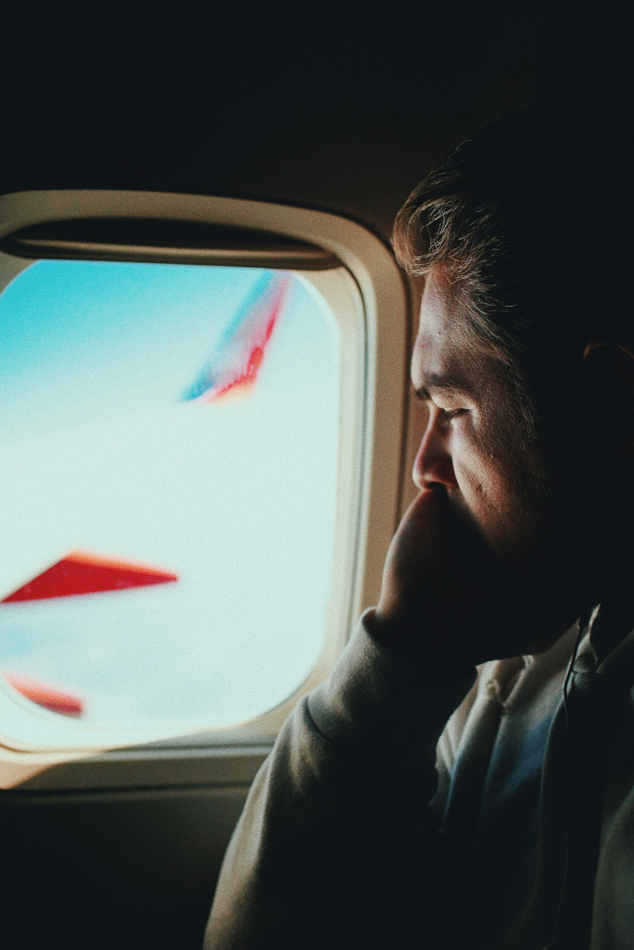 A man in an airplane looking through the window | Source: Unsplash