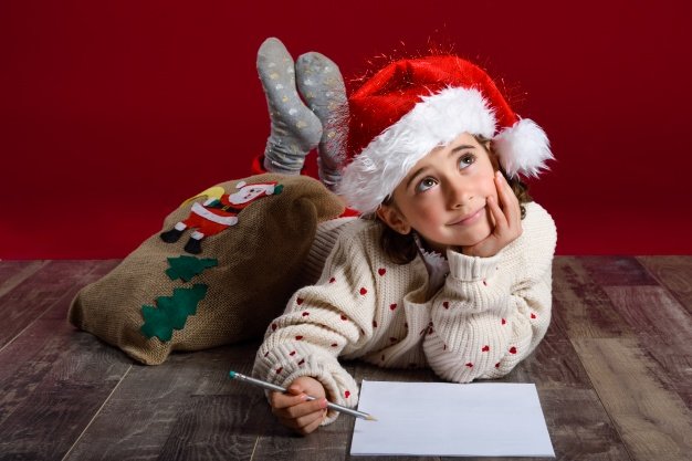 Niña escribiendo carta navideña. │Foto: Freepik