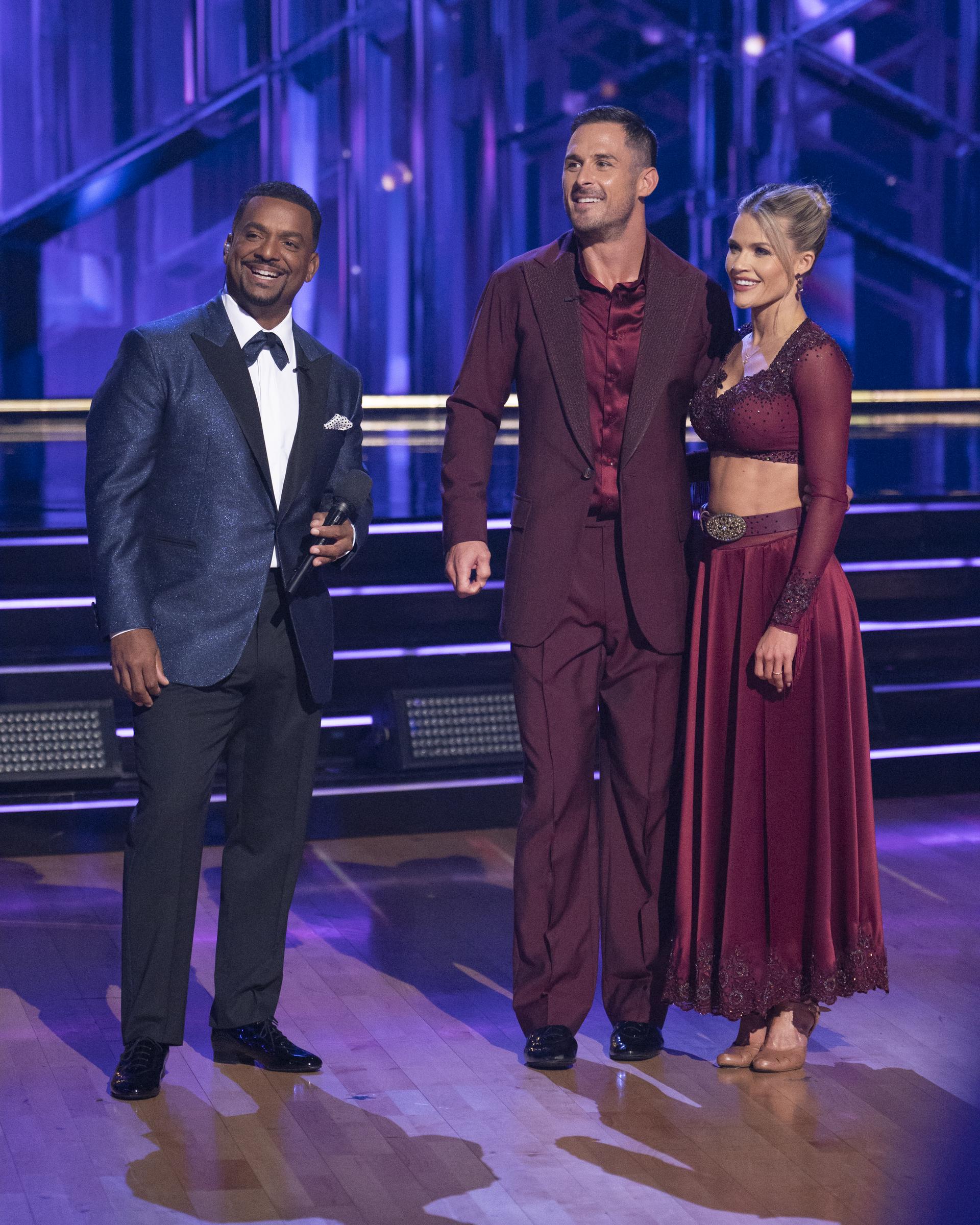 Alfonso Ribeiro standing with Danny Amendola and Witney Carson as they received their scores from the judges during the "DWTS" finale on November 26, 2024. | Source: Getty Images