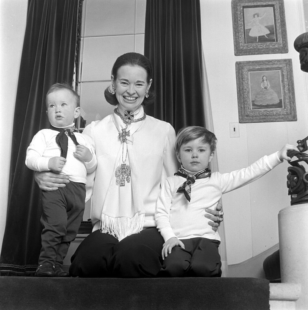 Gloria Vanderbilt poses for a portrait session with her sons Anderson Cooper (L) and Carter Vanderbilt Cooper (R) in their home in circa 1969 in Southampton, Long Island, New York | Photo: Jack Robinson/Hulton Archive/Getty Images