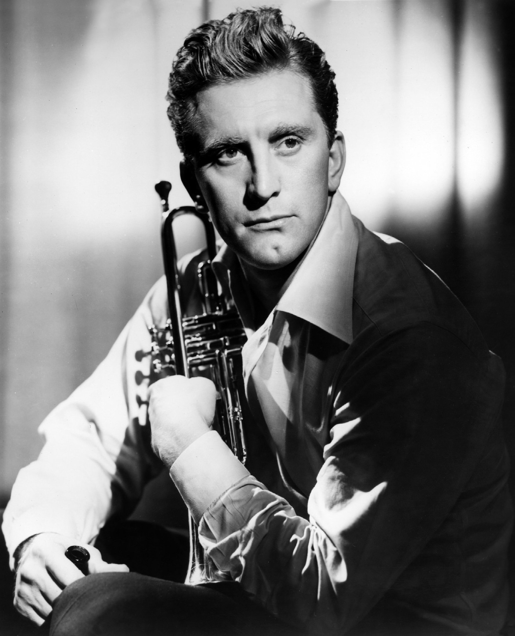 Kirk Douglas as Rick Martin holding a trumpet in the 1949 musical drama "Young Man with a Horn."  | Source: Getty Images