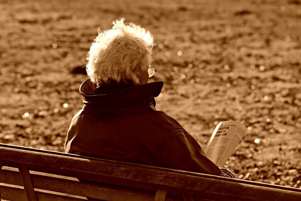 Un personne âgé avec un journal. | Photo : Pixabay