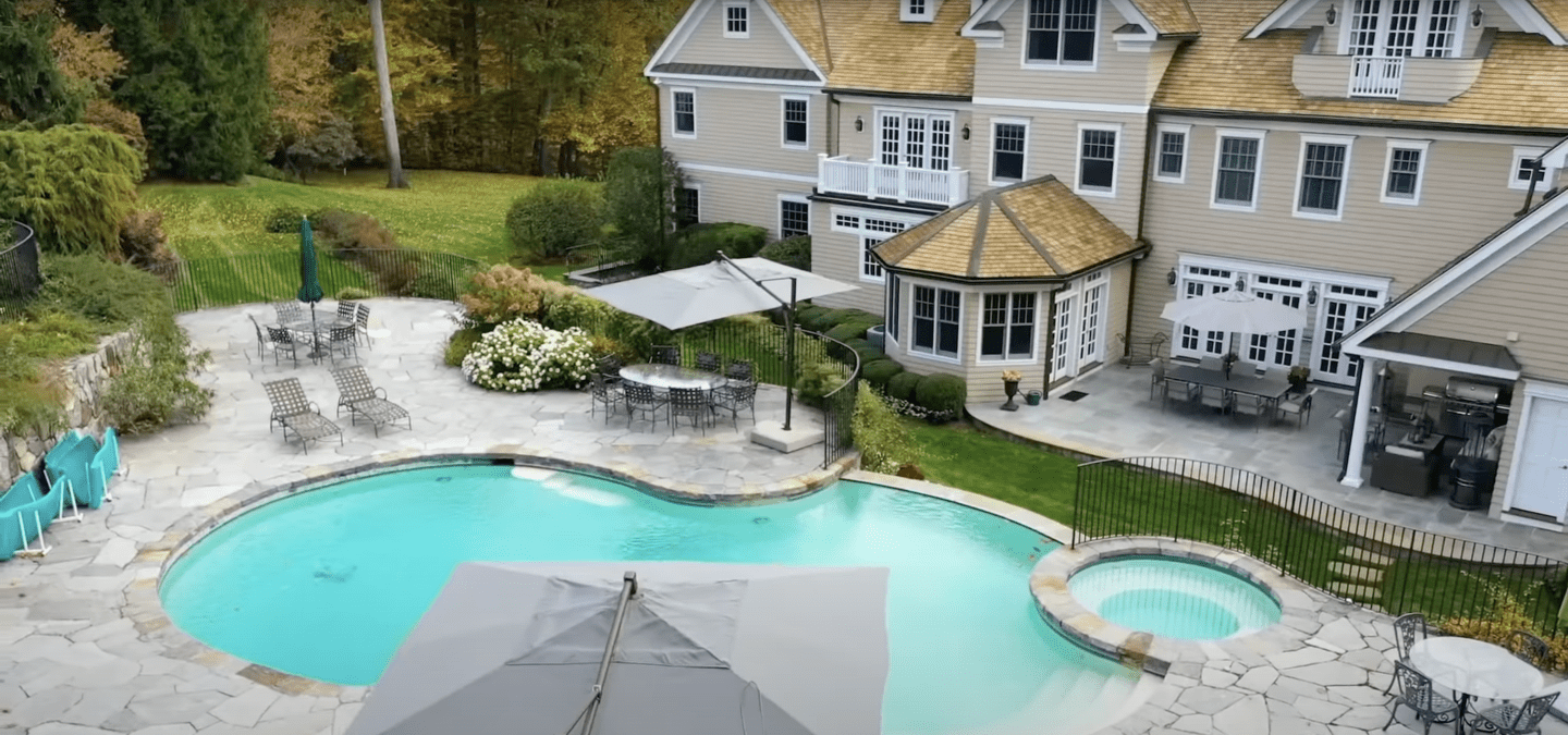 Liam Neeson and Natasha Richardson's backyard outdoor pool that has a quaint pool house. / Source: YouTube/@The Richest