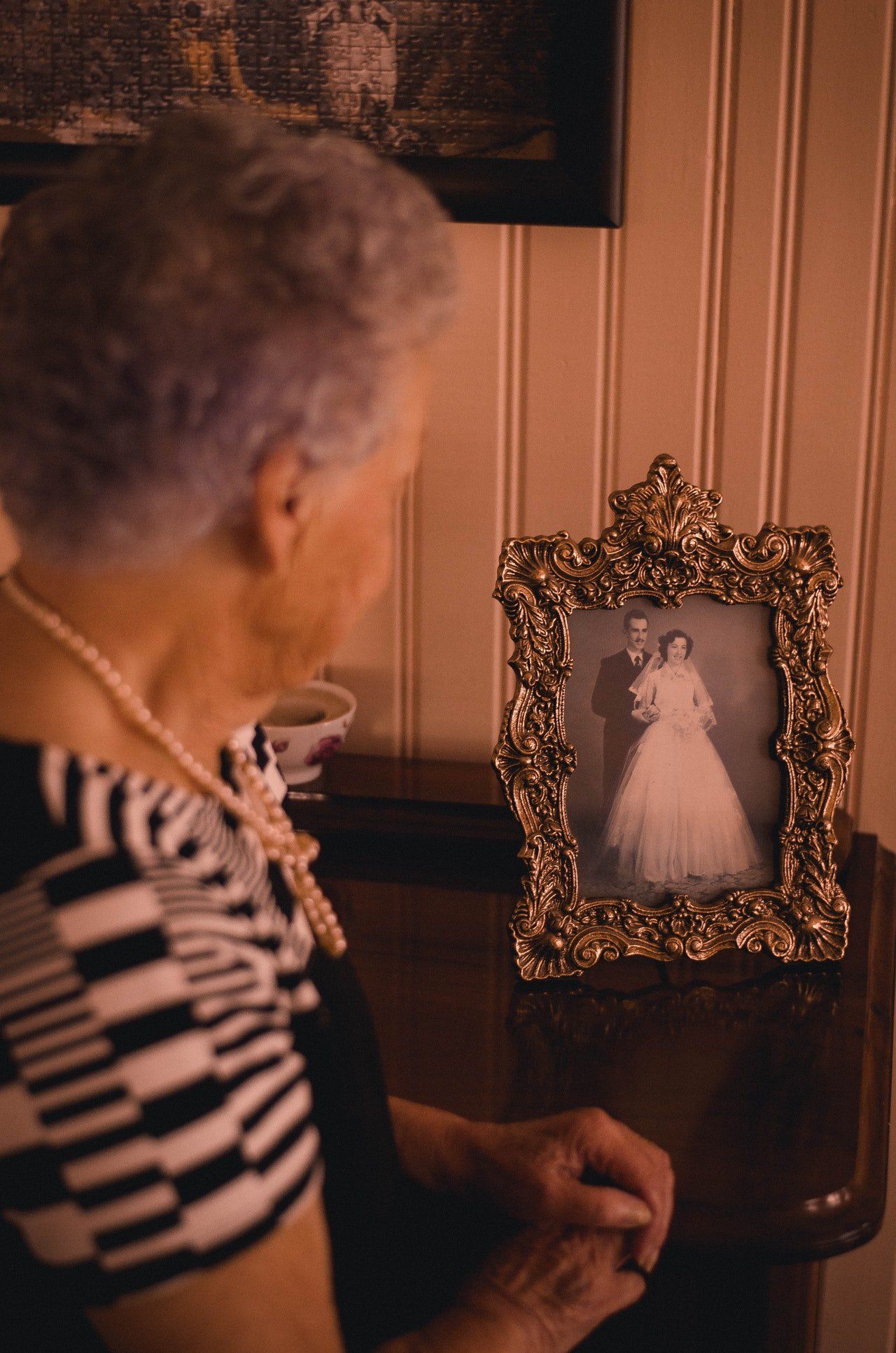 Grandmother looking at portrait | Source: Pexels