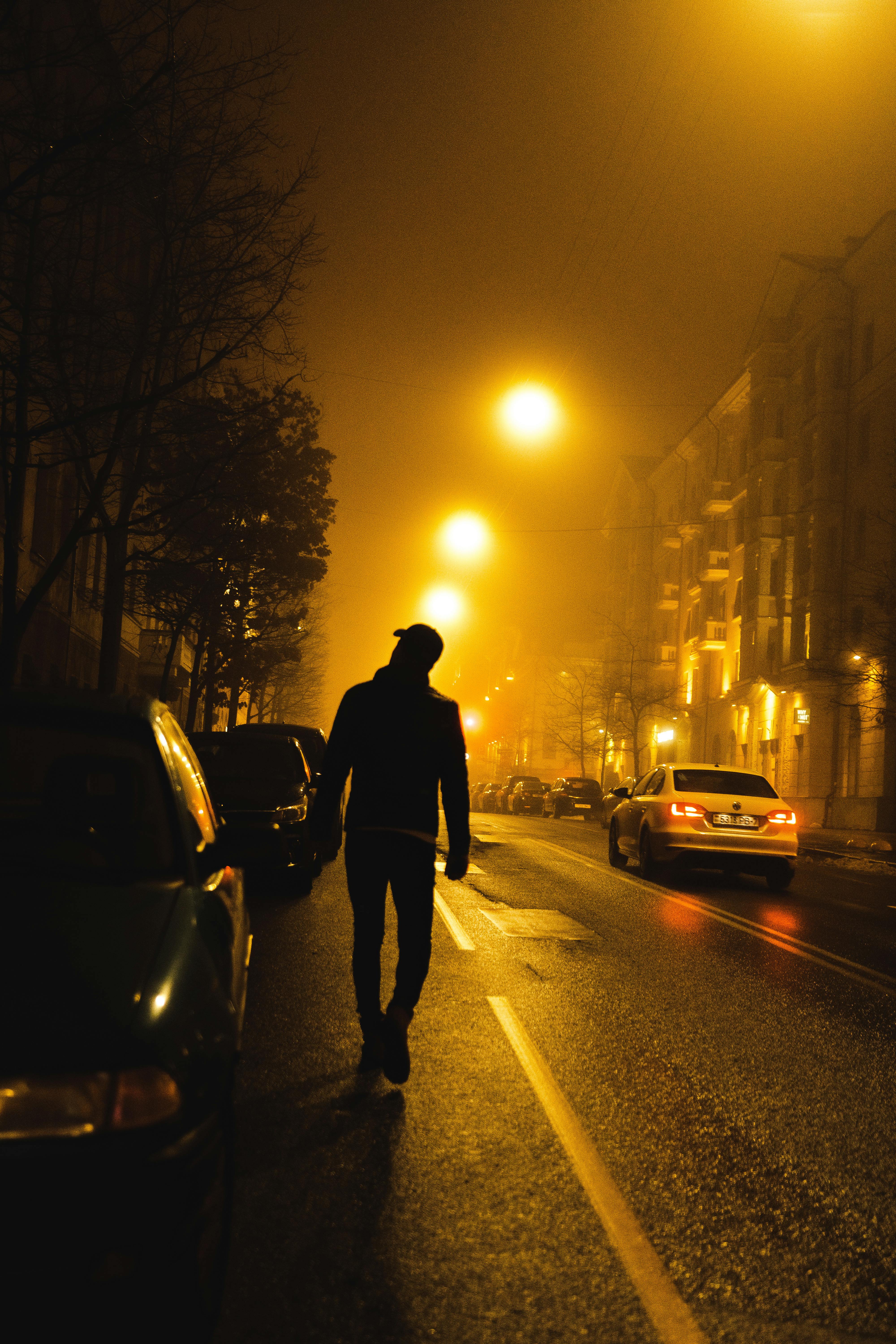 A man walking on sidewalk during night | Source: Pexels