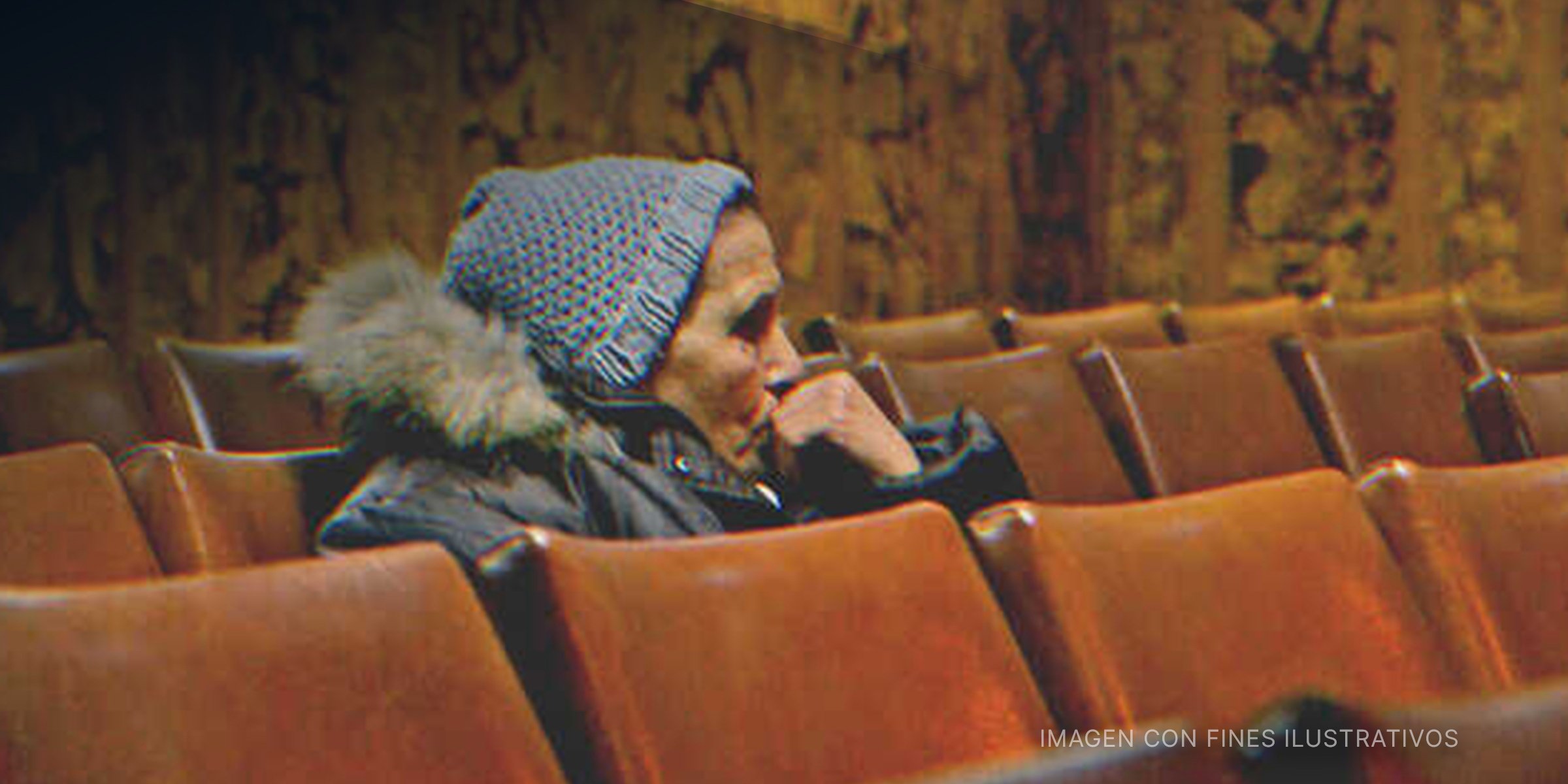 Una mujer mayor sentada en un auditorio. | Foto: Getty Images