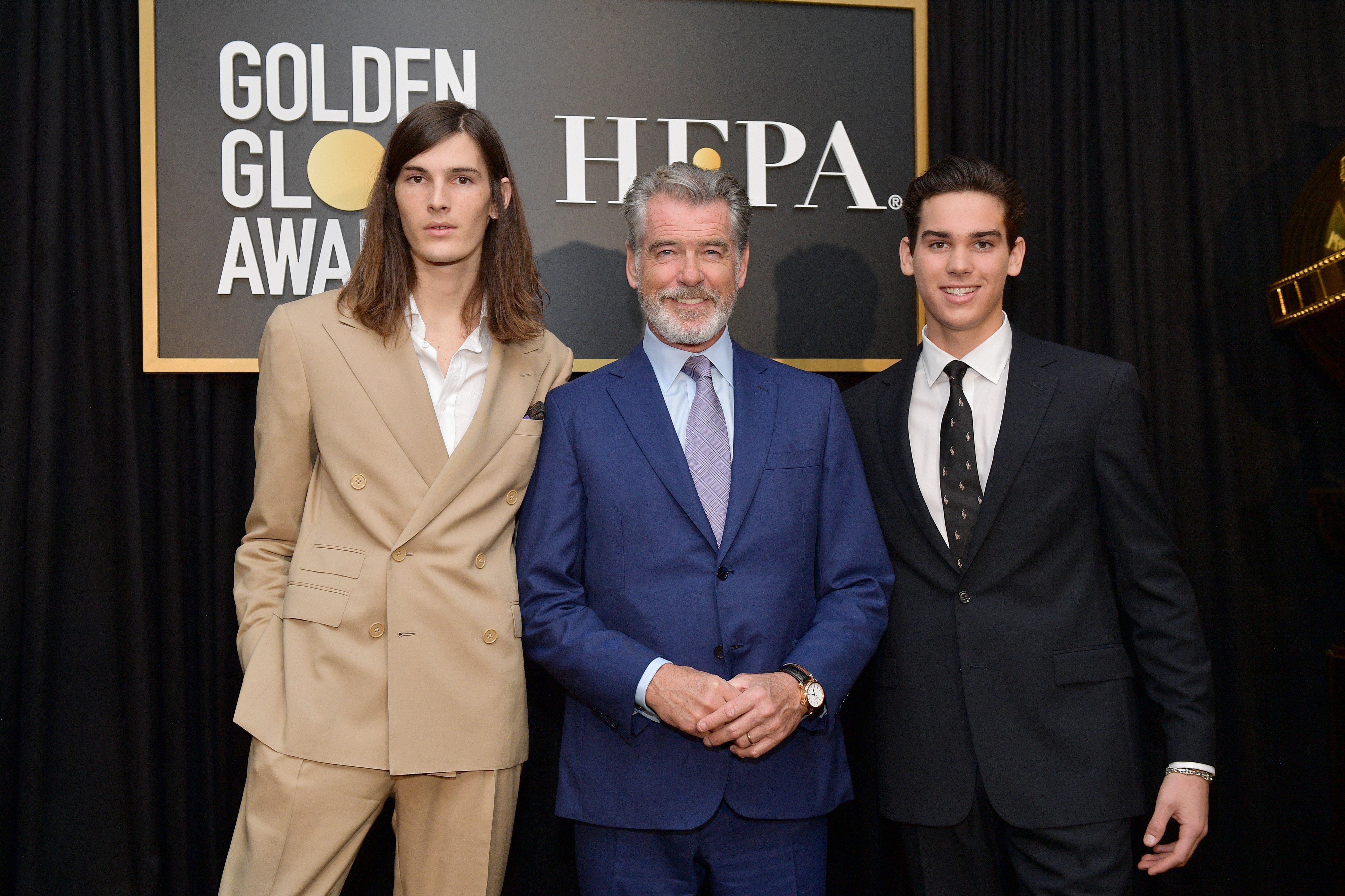 Pierce Brosnan (C) poses with Golden Globe Ambassadors Dylan Brosnan (L) and Paris Brosnan onstage during the Hollywood Foreign Press Association and The Hollywood Reporter Celebration of the 2020 Golden Globe Awards Season. | Source: Getty Images.