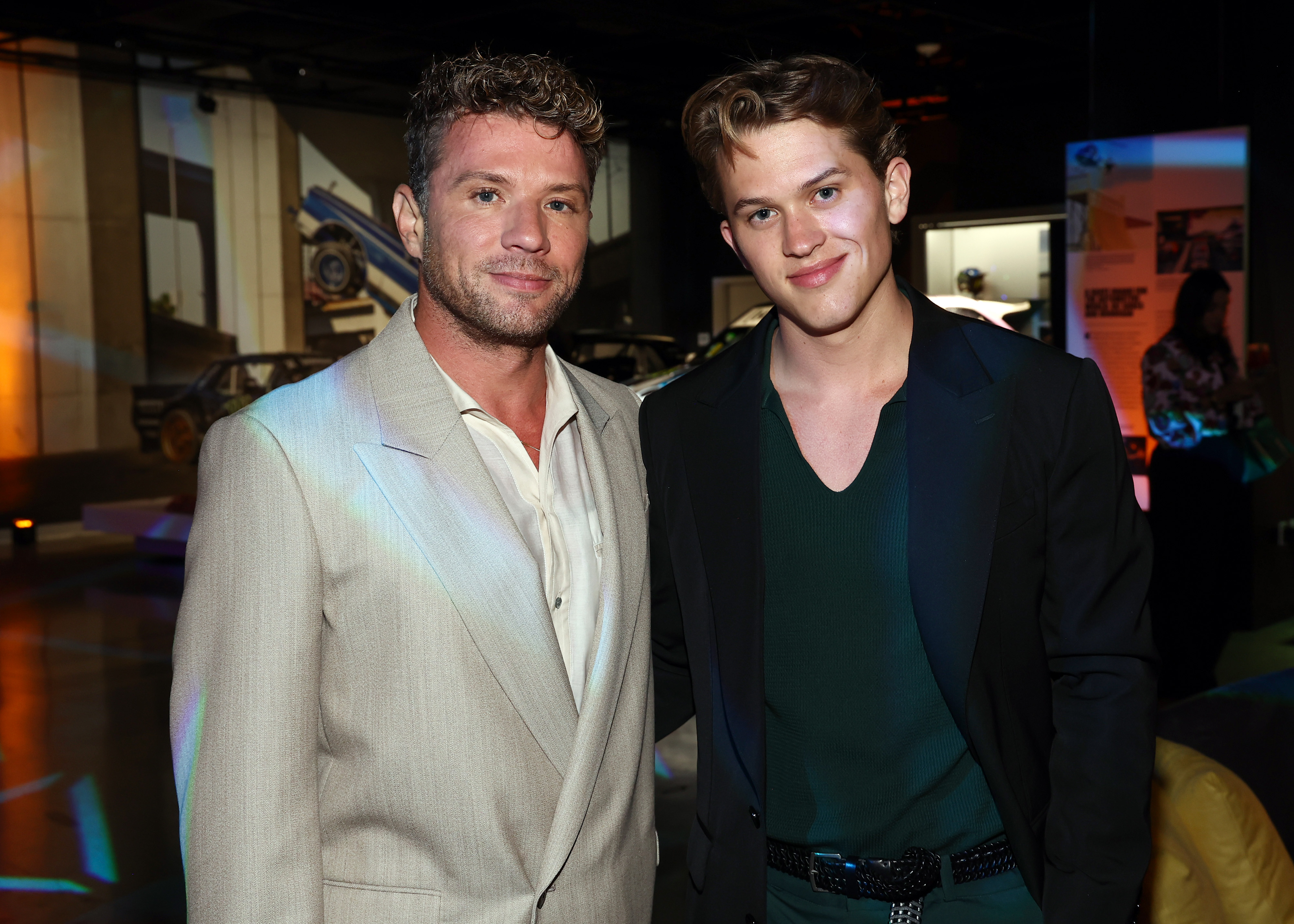 Ryan Phillippe and his son Deacon Phillippe arrive in style at the Petersen Automotive Museum for Prime Video's "Motorheads" red carpet and screening, with Ryan in a light beige suit and Deacon in a forest green knit shirt and black blazer.