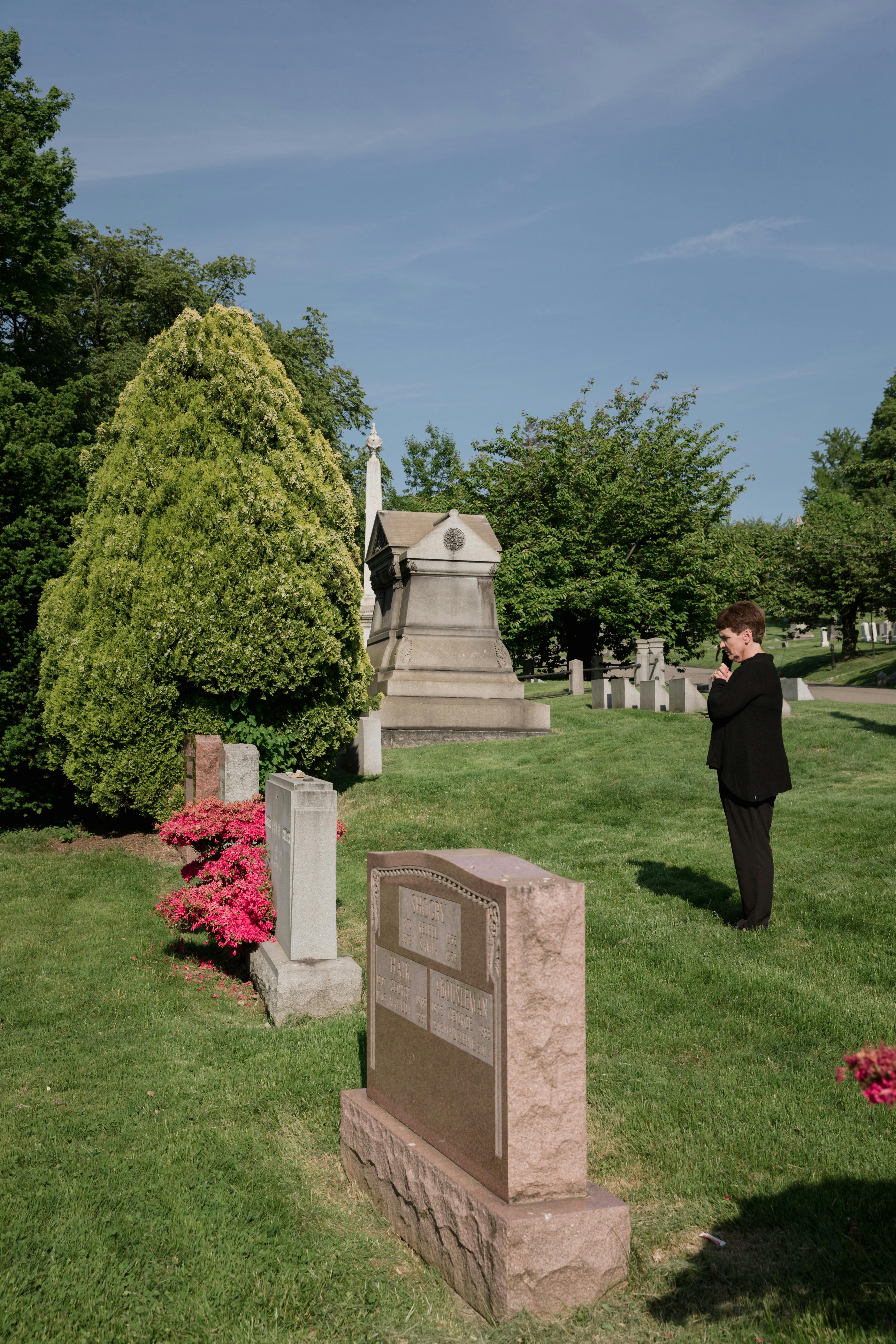 A woman standing in front of a grave | Source: Pexels