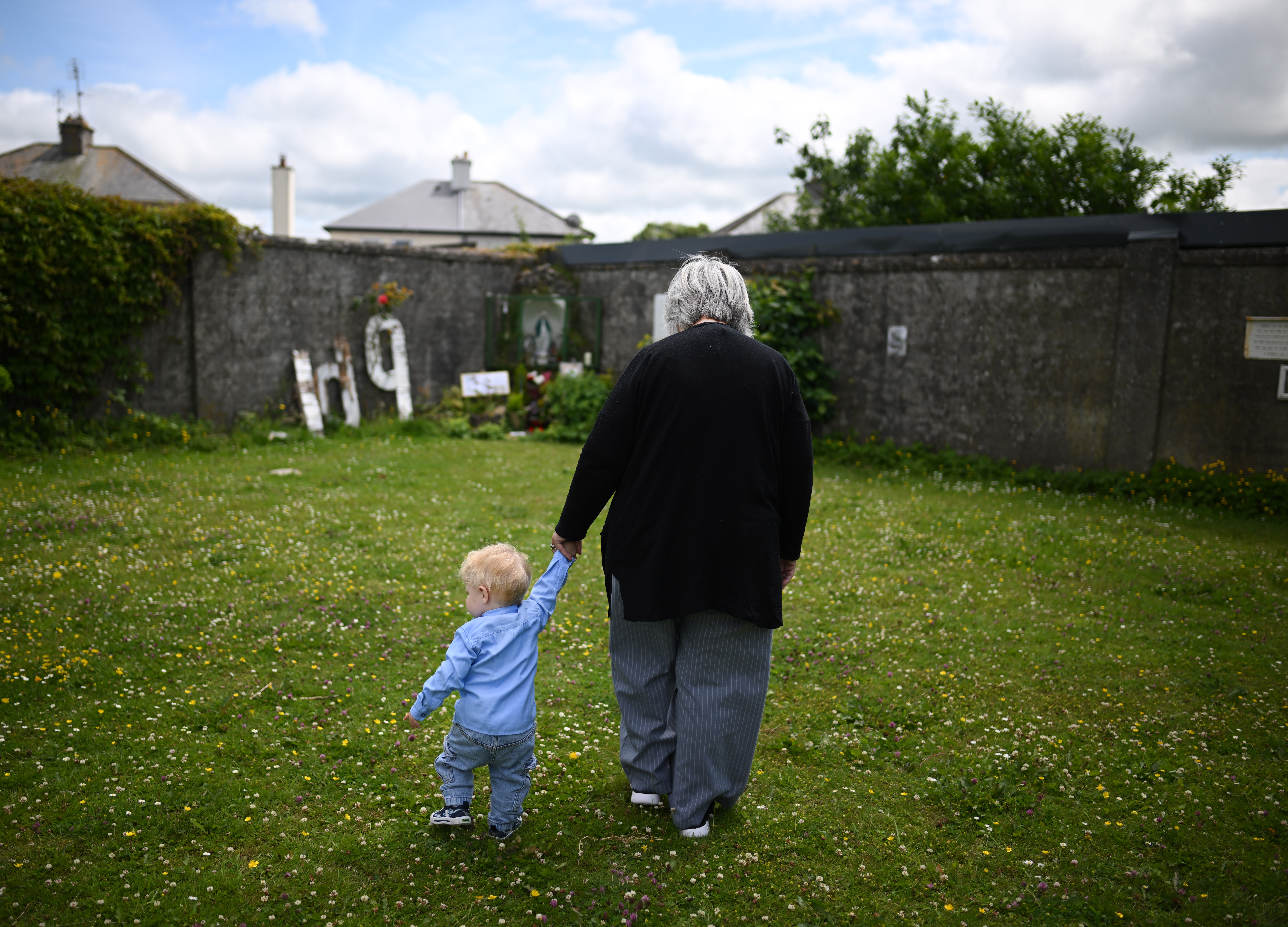 A grandmother and her grandson take a final walk around the Tuam Mother and Baby home remembrance garden on June 15, 2025 | Source: Getty Images