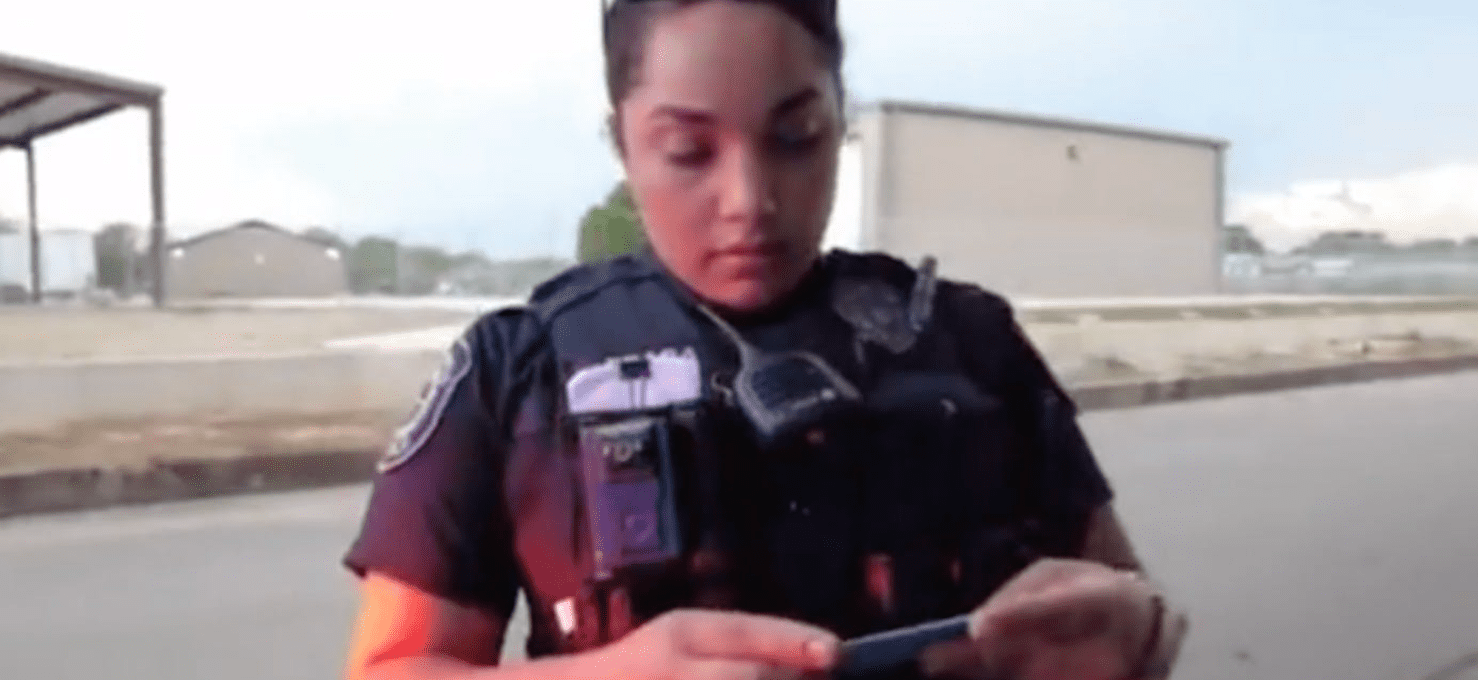 An officer inspects a man's license card and tells him he is in violation of the law | Photo: TikTok/notthisagainla
