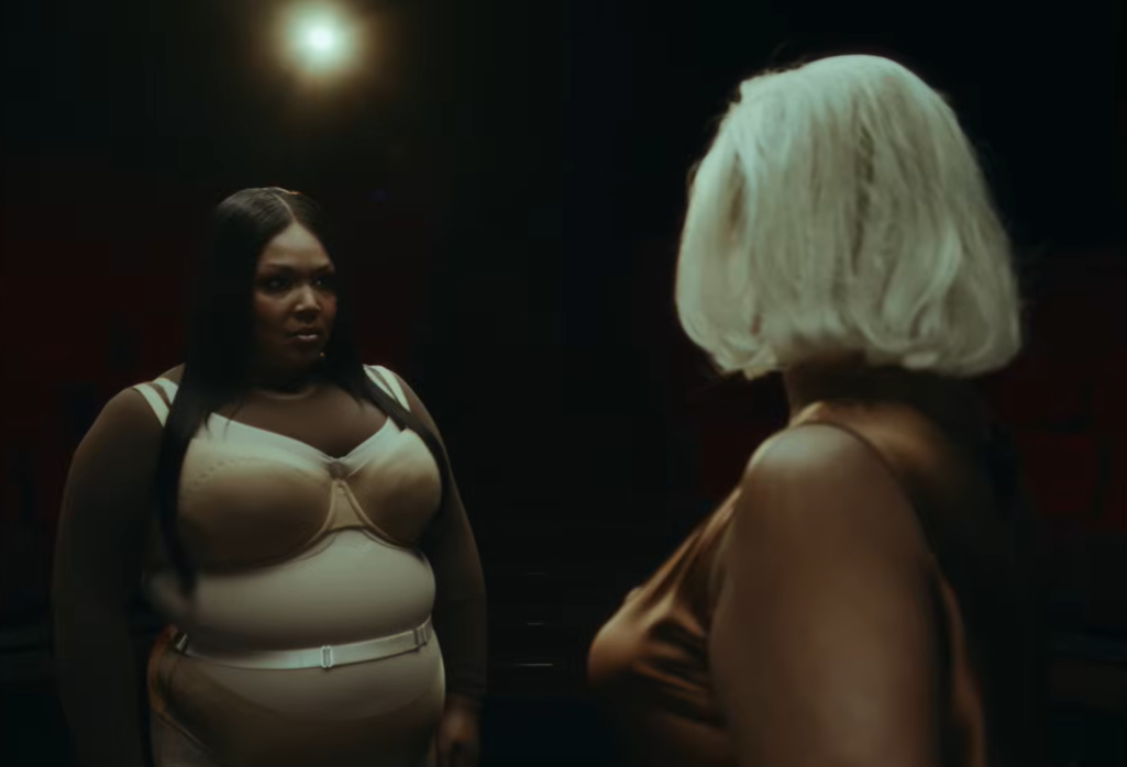 Lizzo faces her alter ego directly, holding eye contact in a quiet confrontation | Source: YouTube/Lizzo
