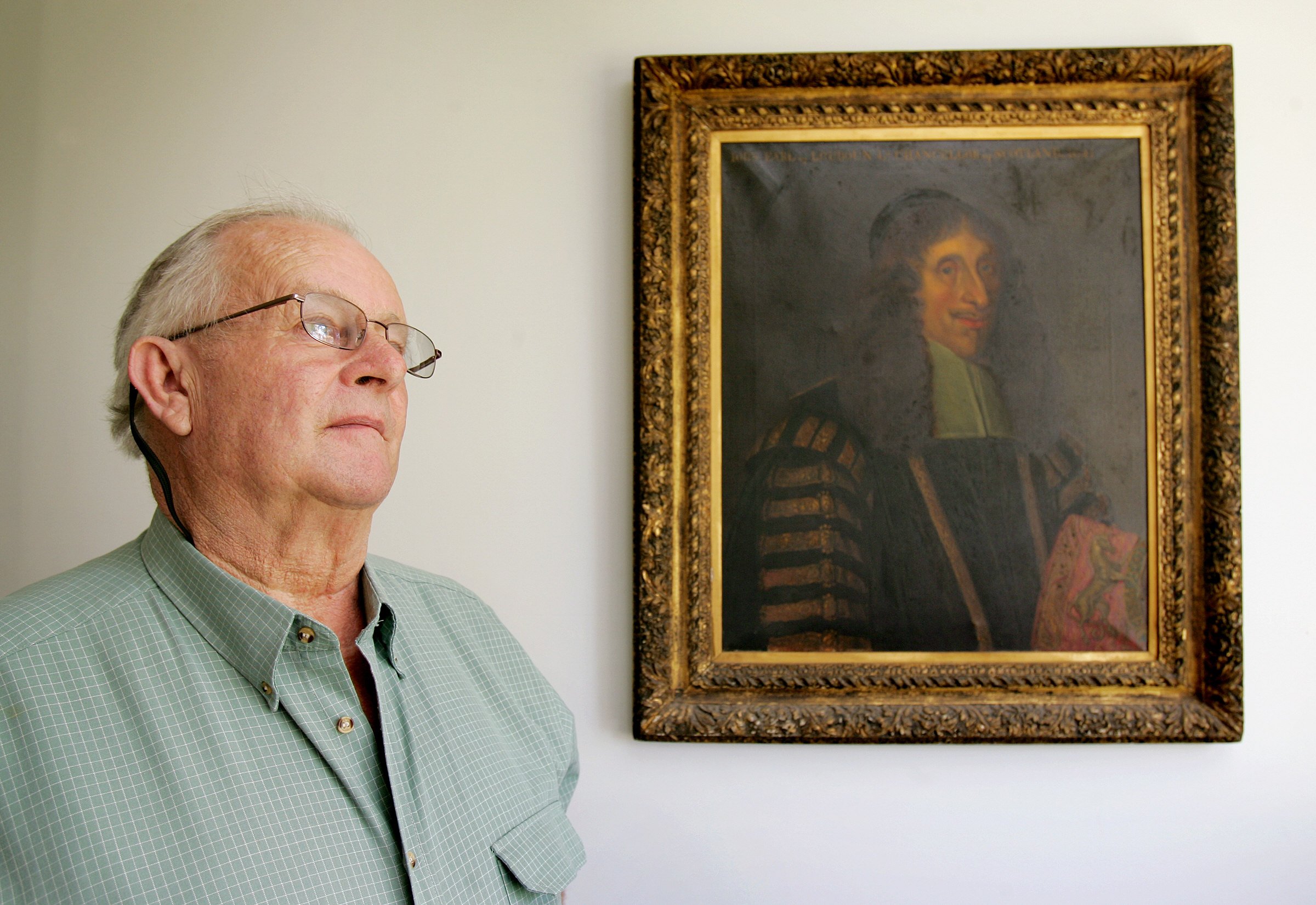 Michael Hastings posing in front of a portrait of a relative in his home on 02 October 2005 in Jerilderie, Australia. / Source: Getty Images