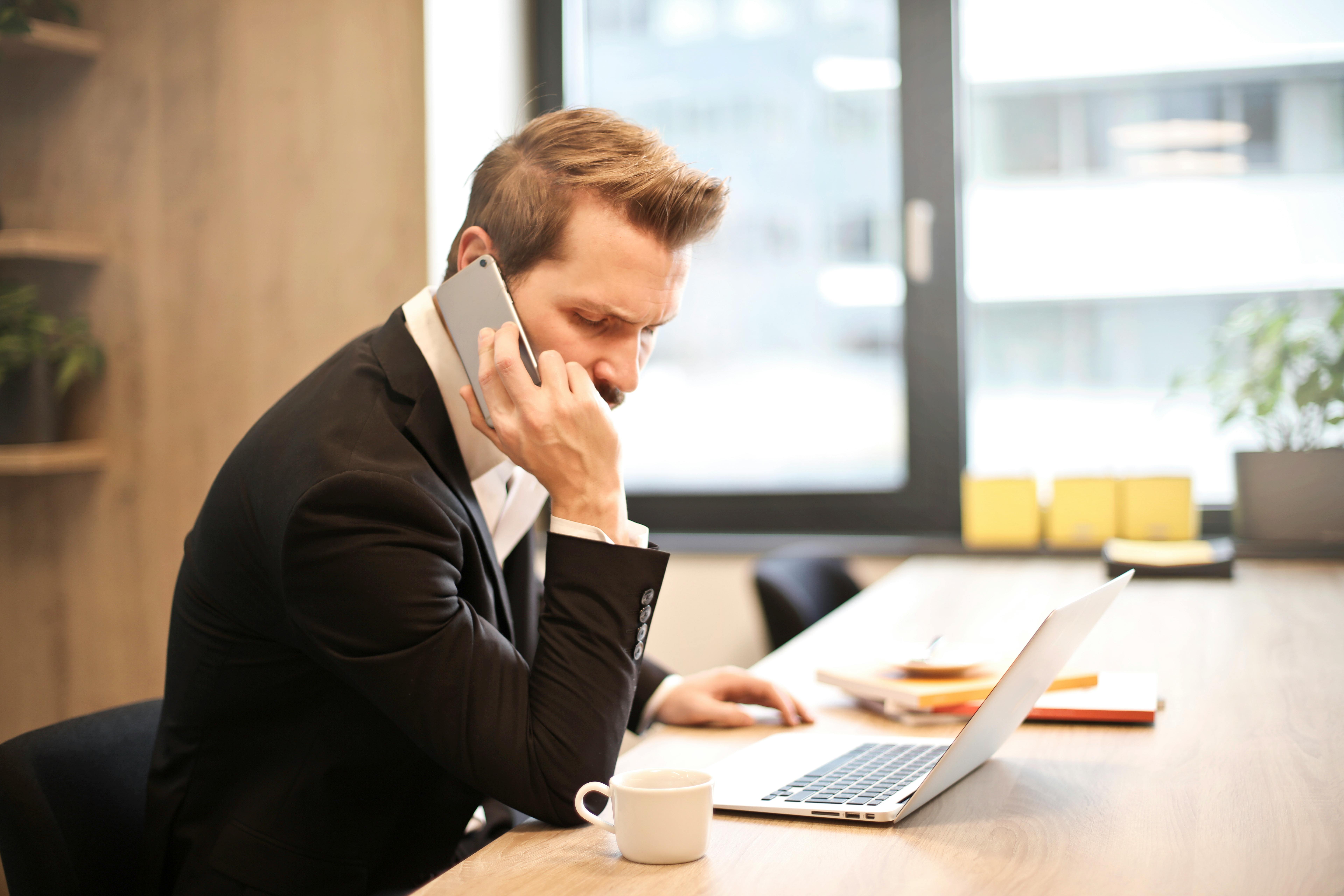 Man talks on the phone in his office | Source: Pexels