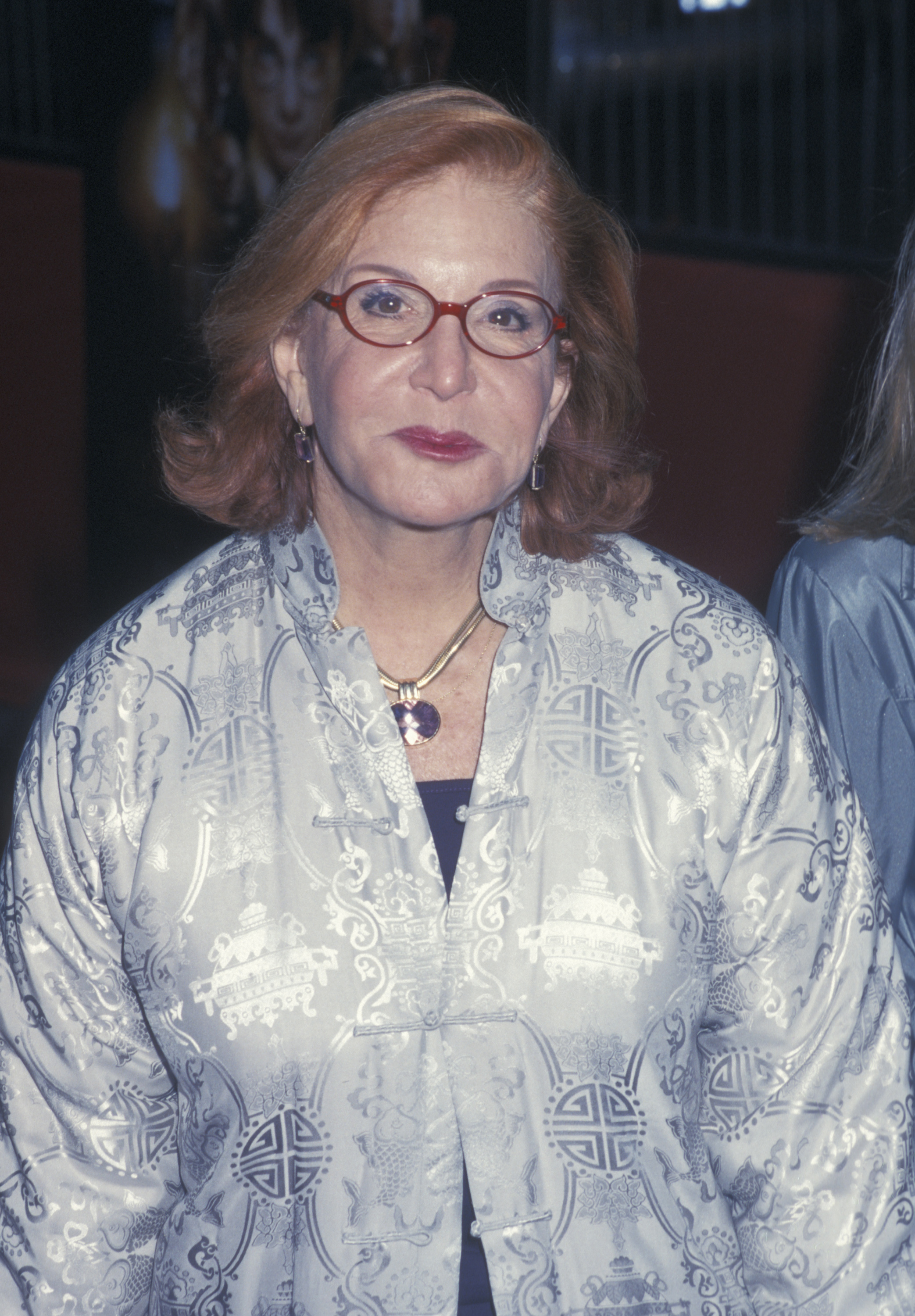 Sally Jessy Raphael attends the premiere of "Harry Potter and the Sorcerer's Stone" at the Ziegfeld Theater in New York City on November 11, 2001. She wears a silver patterned jacket with her iconic red glasses and a gemstone necklace for the magical movie debut.