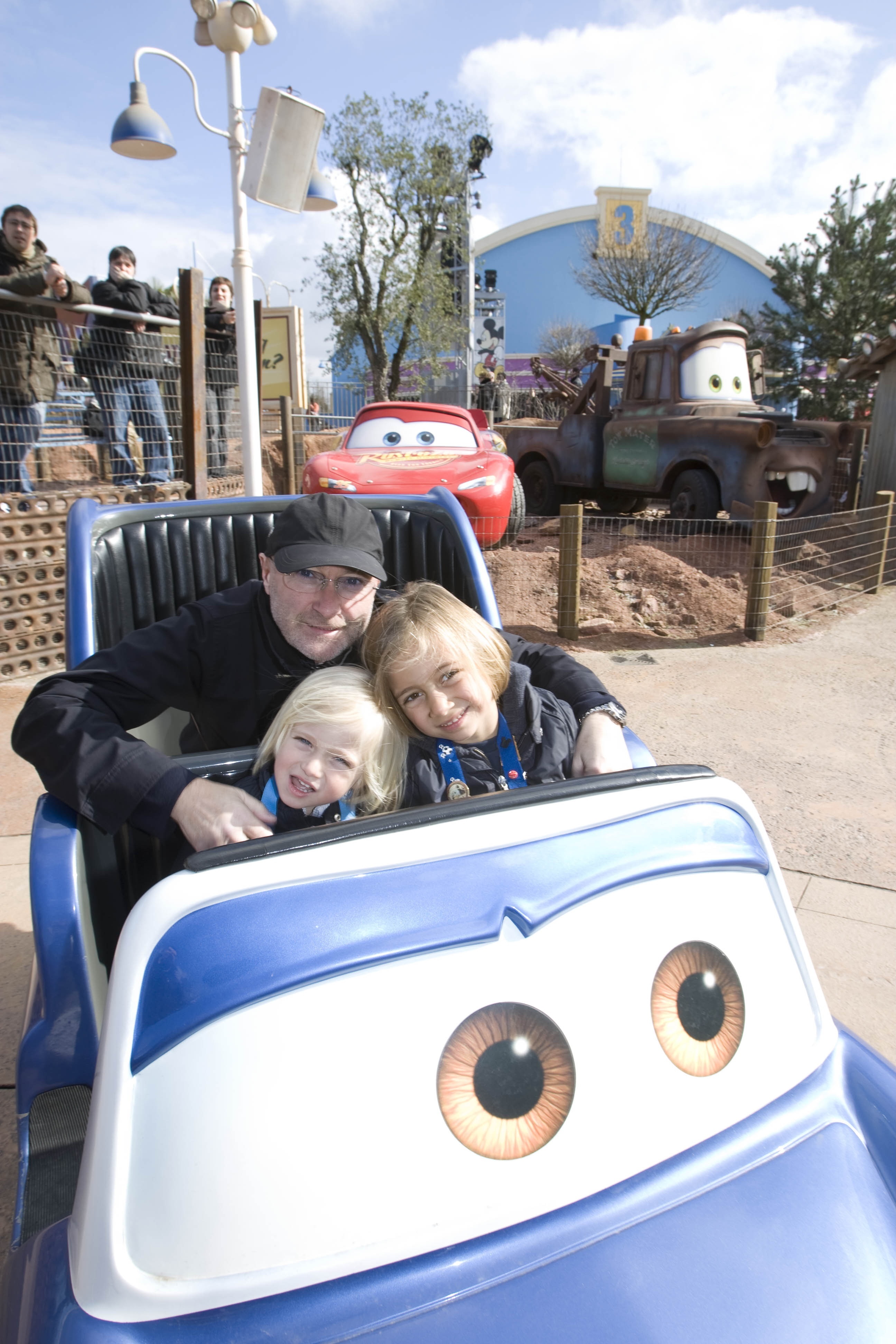 Phil Collins wraps his arms around a young Matthew and Nicholas Collins as the three squeeze into a Cars-themed ride at Disneyland Paris on 5 April 2008. A fair-haired Matthew, around three years old at the time, grins from the front seat with Lightning McQueen and Mater visible in the background — a far cry from the Austrian football pitches he would one day call his workplace.