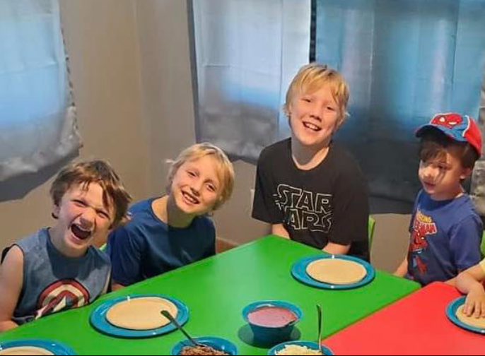 Caleb Moore and some children are photographed with smiles on their faces, from a post dated June 12, 2025 | Source: Facebook/AshleyBentz