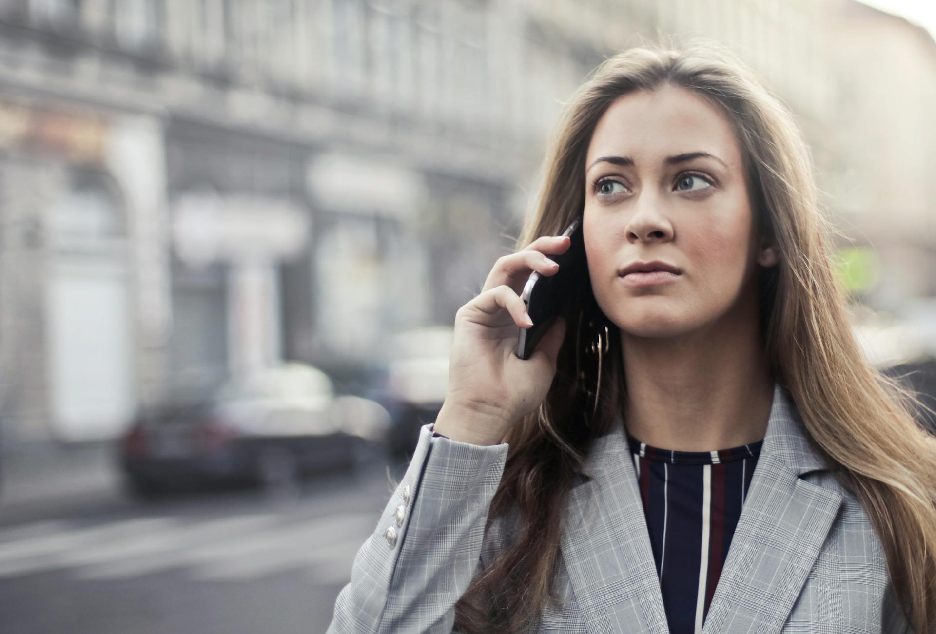 A woman with a grim look speaking on the phone | Source: Pexels