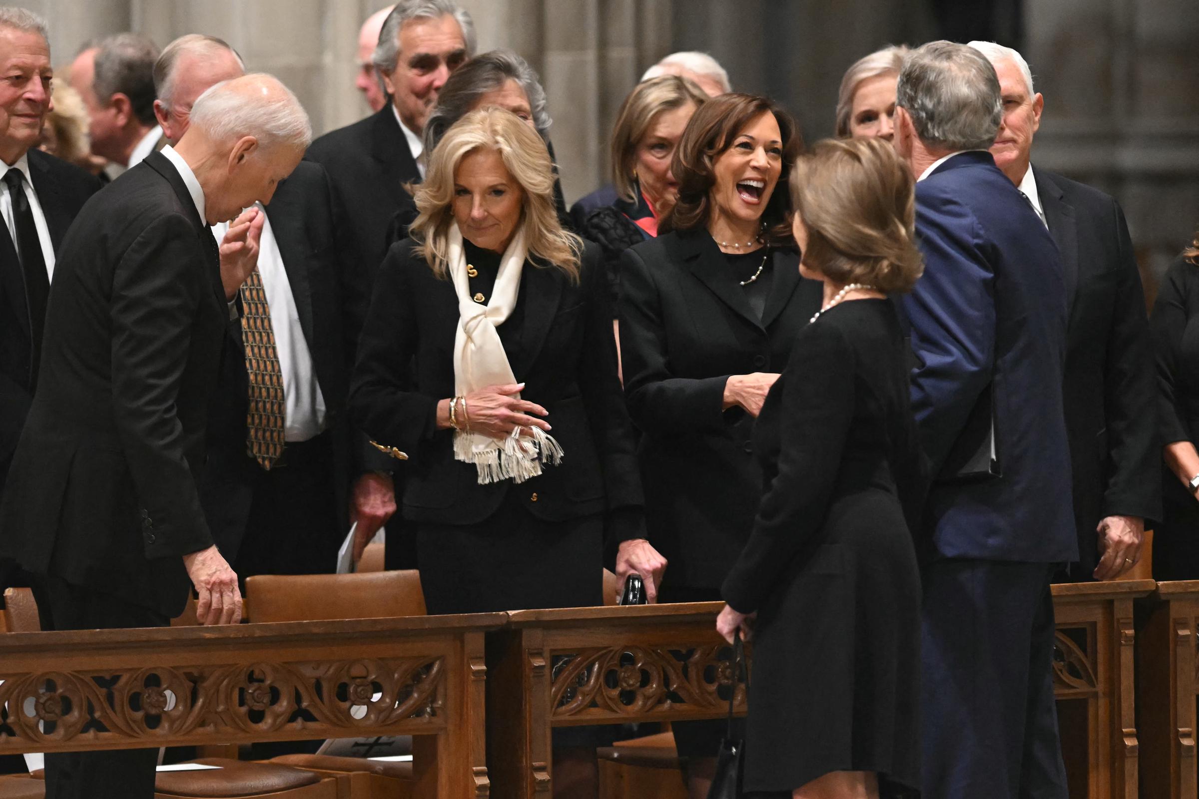 Joe and Jill Biden in the middle of taking their seats as Kamala Harris greets George W. and Laura Bush at the funeral. | Source: Getty Images