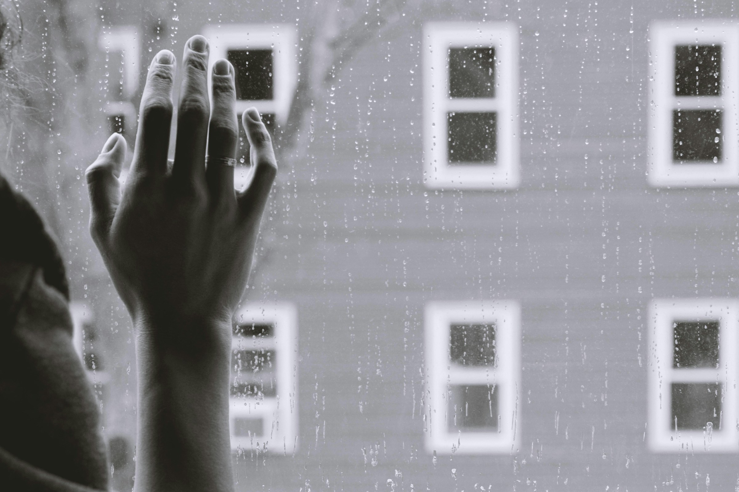 A grayscale photo of a woman's right hand on glass | Source: Pexels