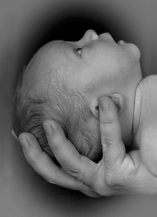 Bebé en manos de un adulto. | Foto: Pixabay