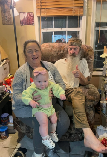 Katy and Phil Robertson pictured with a baby, dated May 2025 | Source: instagram/legitsadierob