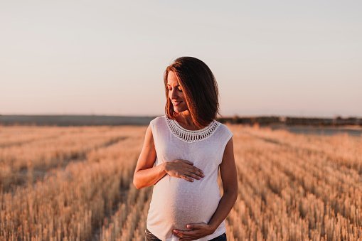 Pregnant woman standing in the field | Photo: Getty Images