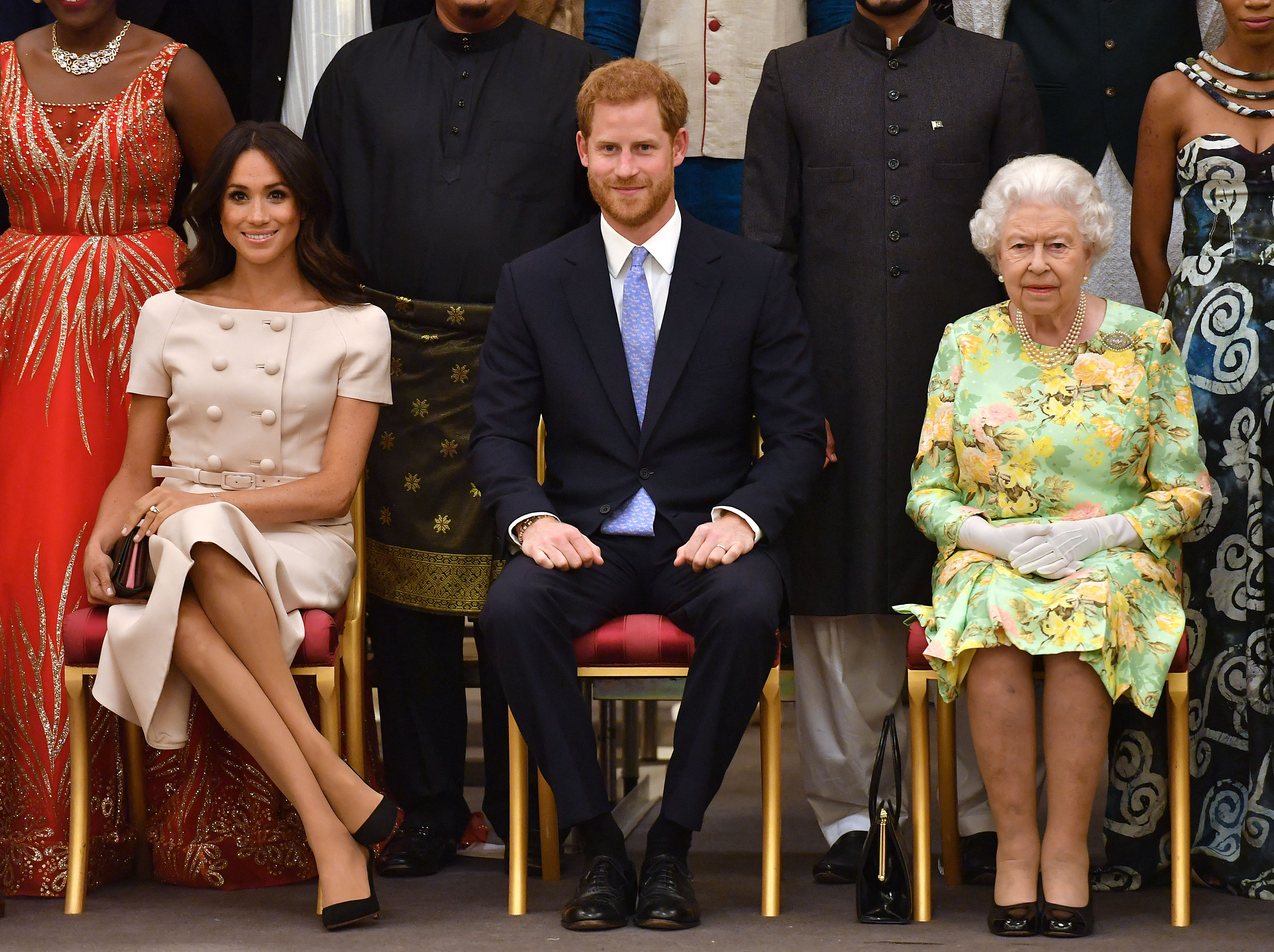 Meghan, Duchess of Sussex, Prince Harry, and the late Queen Elizabeth II were captured in a composed yet symbolic portrait during the Queen's Young Leaders Awards Ceremony at Buckingham Palace on 26 June 2018. Seated side by side, the trio presented a moment of unity across generations — with the Duchess poised and elegant, Prince Harry centred and composed, and the late monarch maintaining her signature dignified presence.