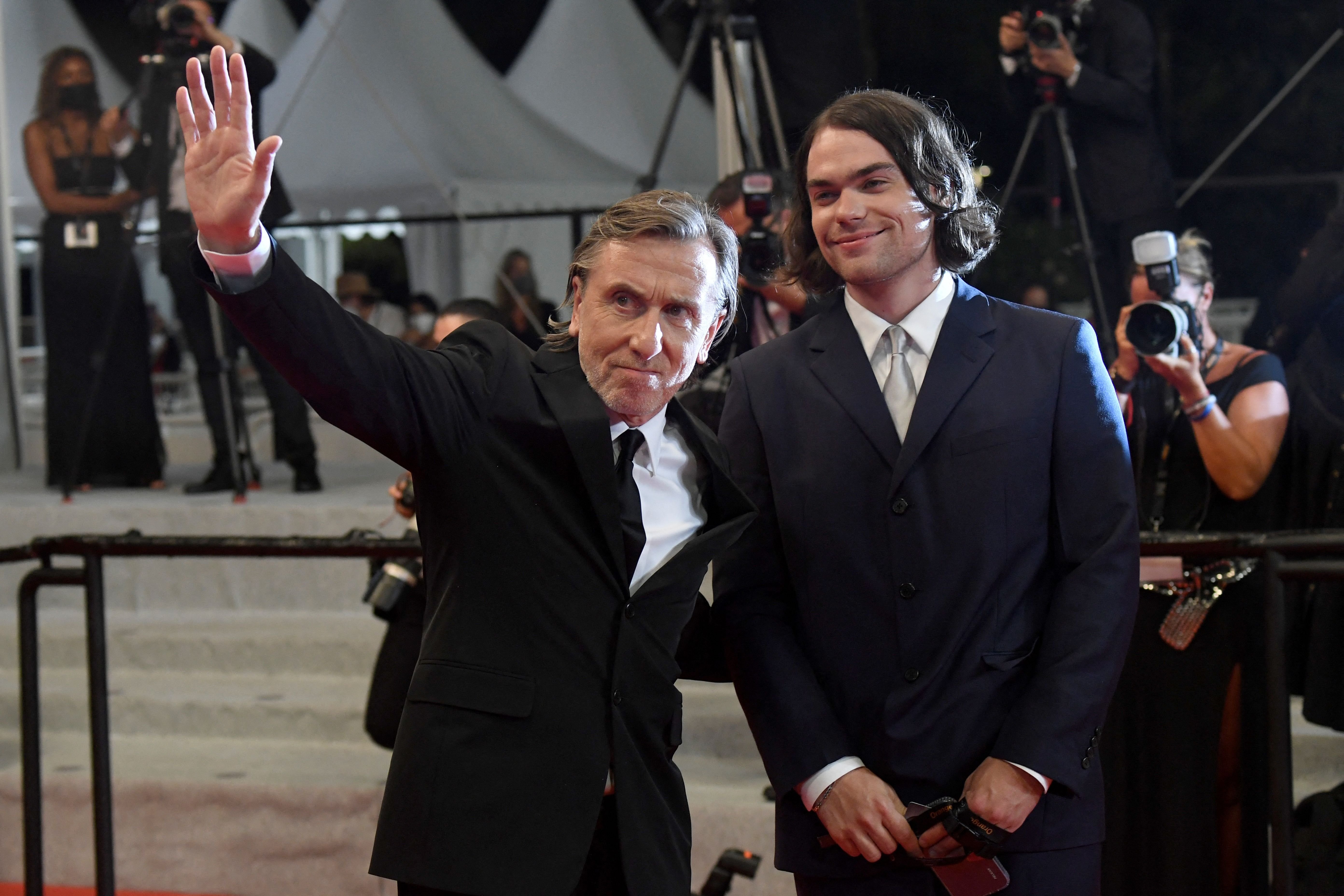British actor Tim Roth (L) waves as he arrives with his son Michael Cormac Roth for the screening of the film "Bergman Island" at the 74th edition of the Cannes Film Festival in Cannes, southern France, on July 11, 2021. | Source: Getty Images