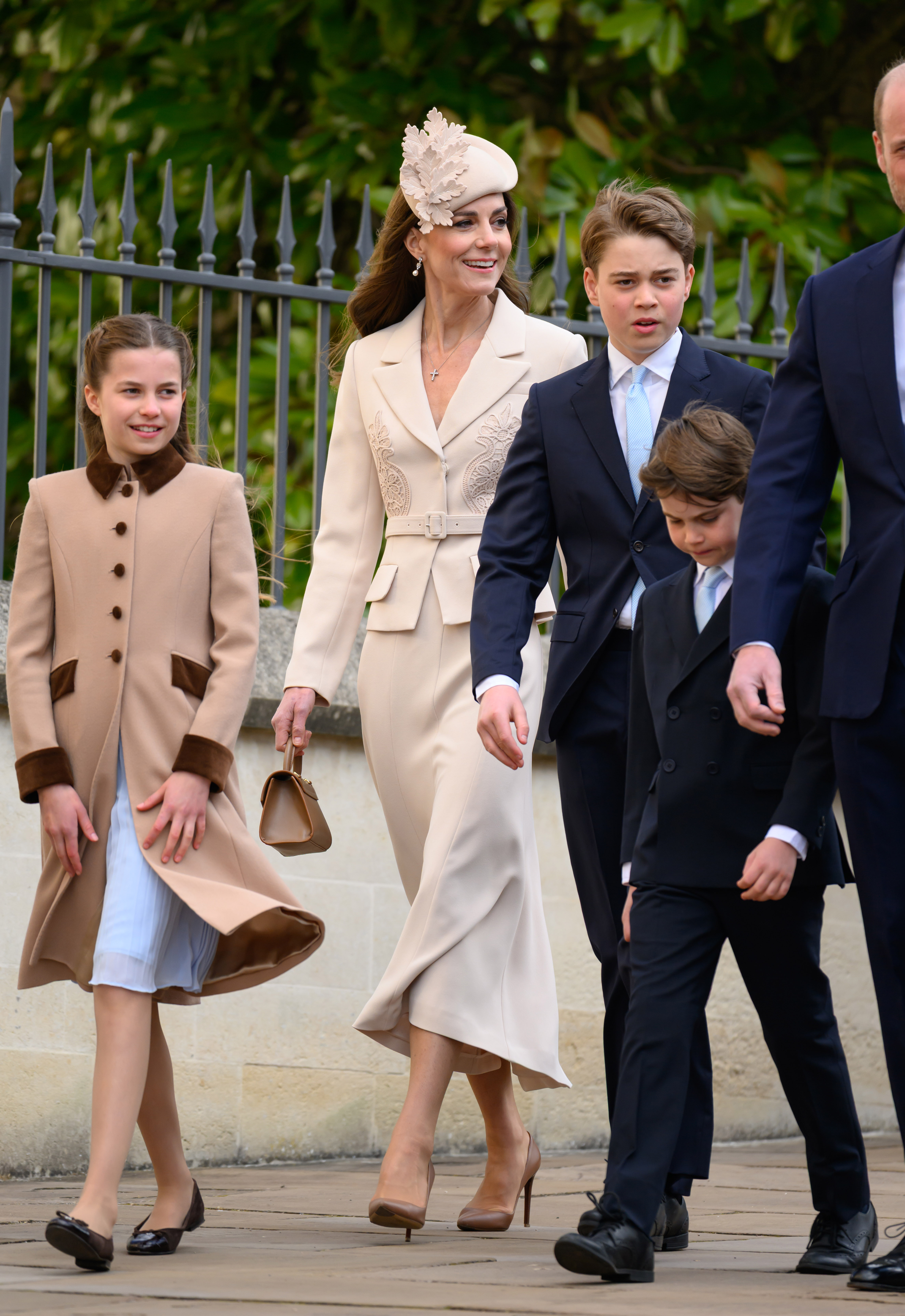 The whole Wales family in step at Windsor, and the photo that explains everything. Princess Charlotte strides out to the left in her camel coat while the Princess of Wales walks at the centre. And then there is Prince George, 12, standing head and shoulders above Prince Louis and drawing level with his mother, the Prince of Wales visible just behind them both.