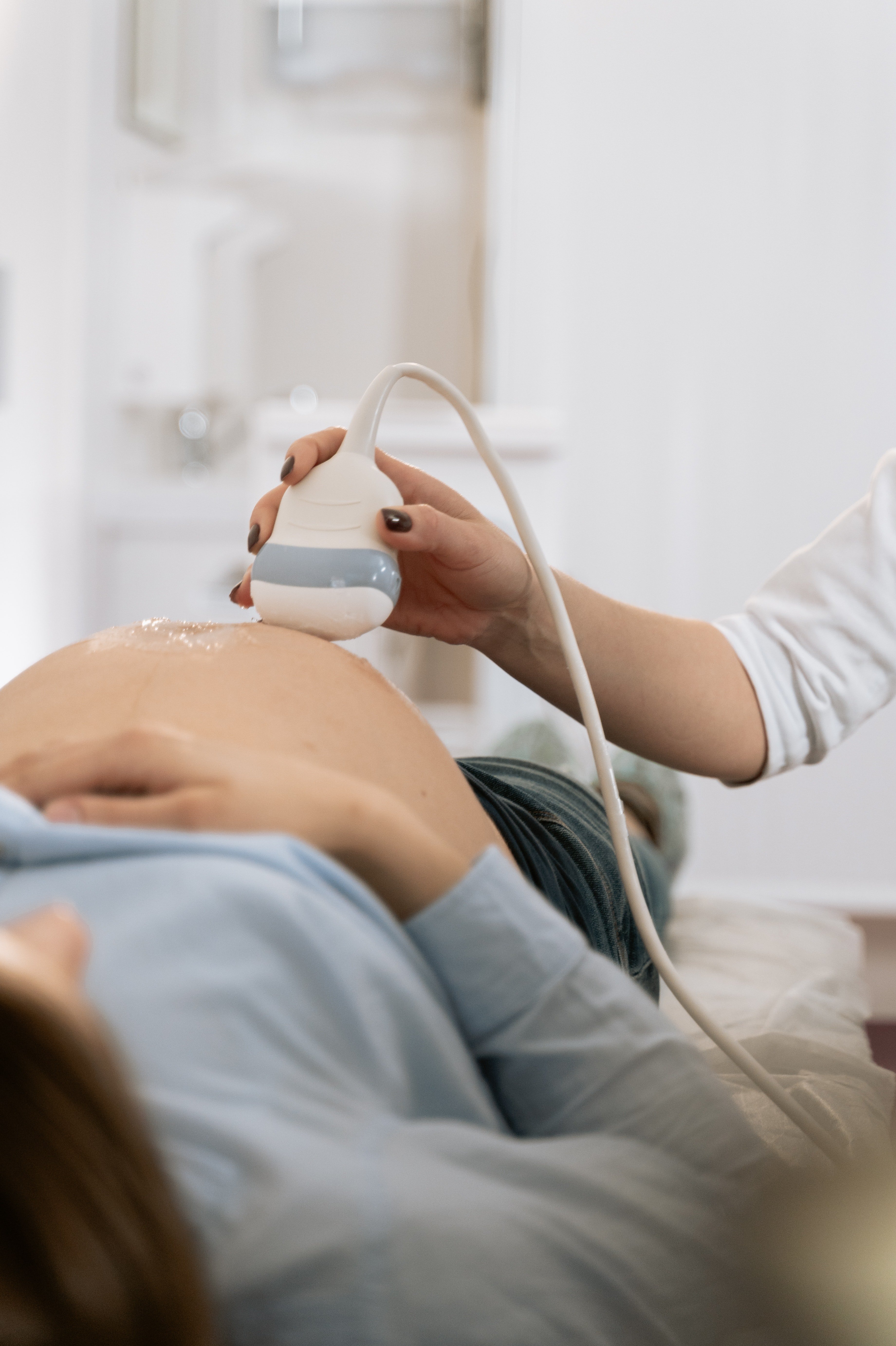 Un médico realizando una ecografía a una mujer con el vientre abultado. | Foto: Pexels