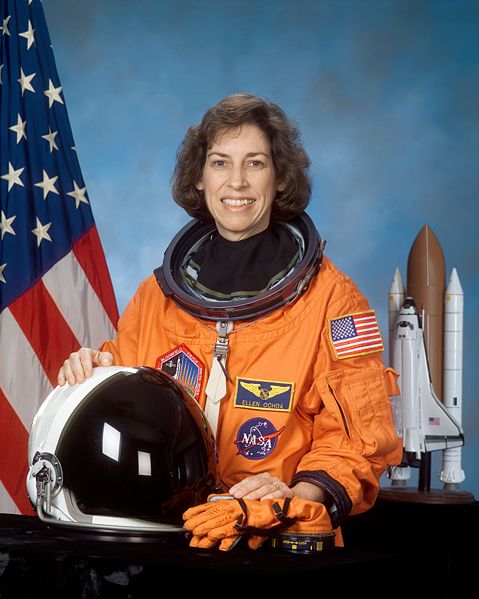 Portrait of Dr. Ellen Ochoa in NASA uniform with U.S. flag in the background | Source: Wikimedia Commons