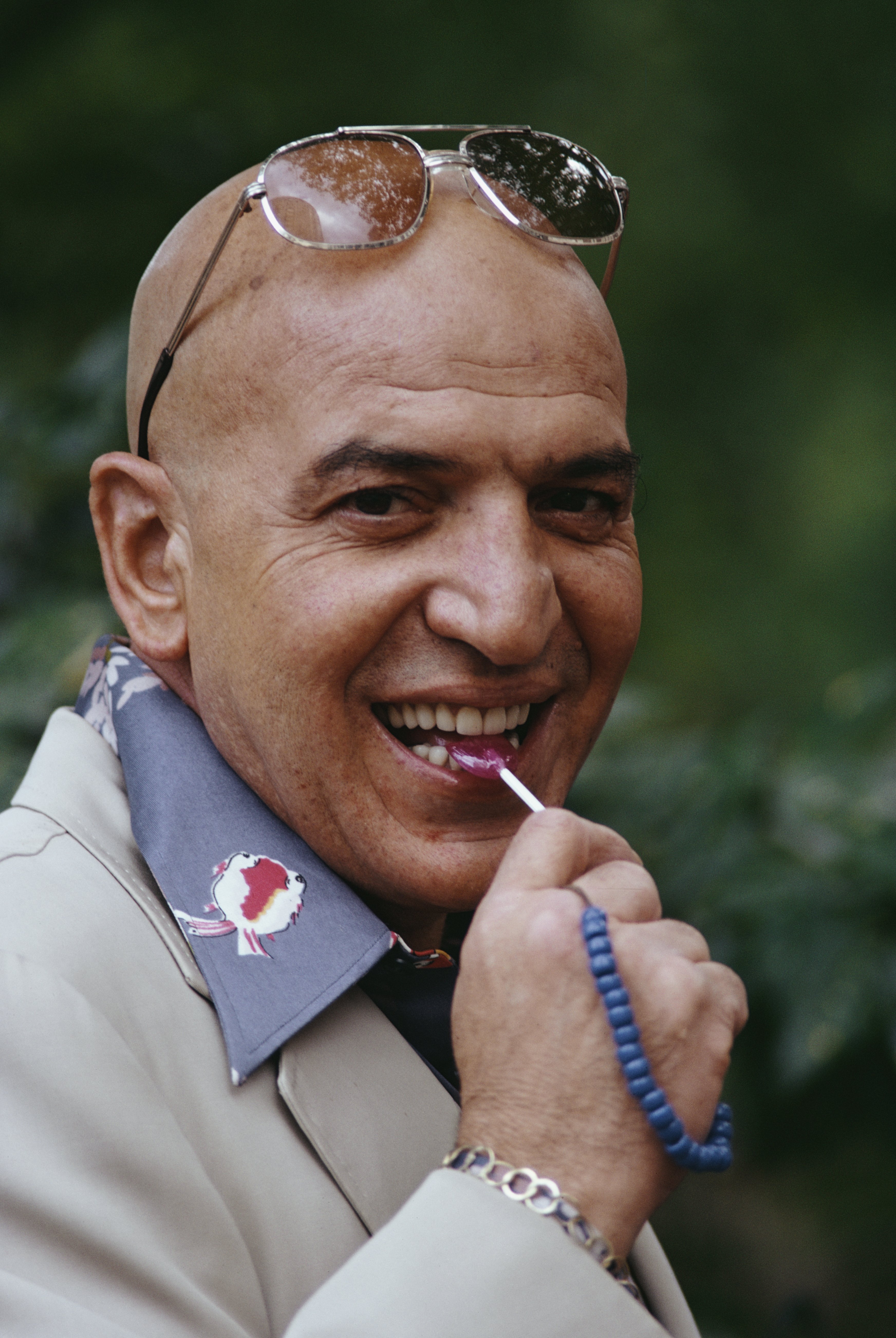 American singer and actor Telly Savalas with trademark lollipop and sunglasses on his head, in 1974. | Source: Tony Evans/Getty Images
