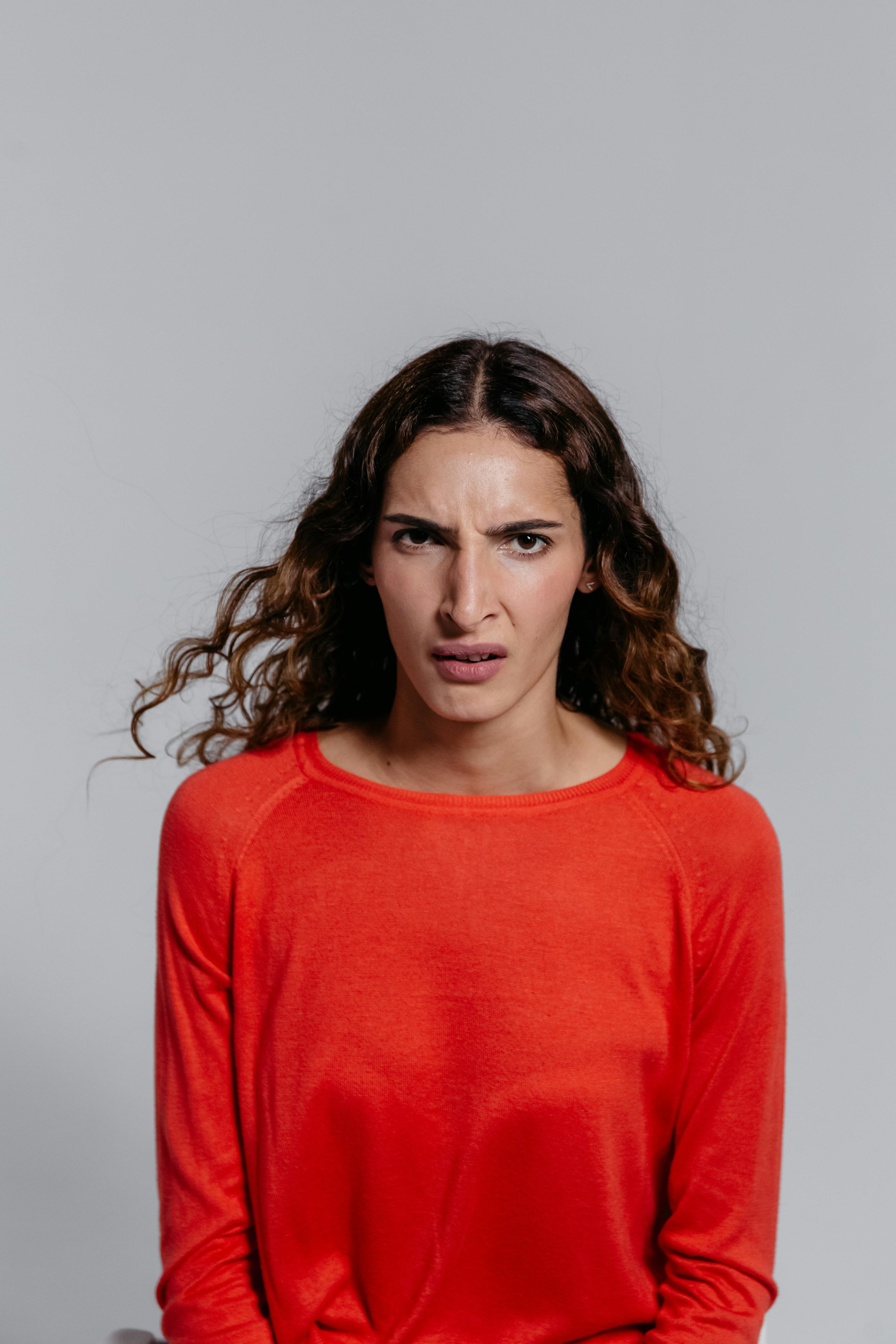 An angry woman in a red sweater | Source: Pexels