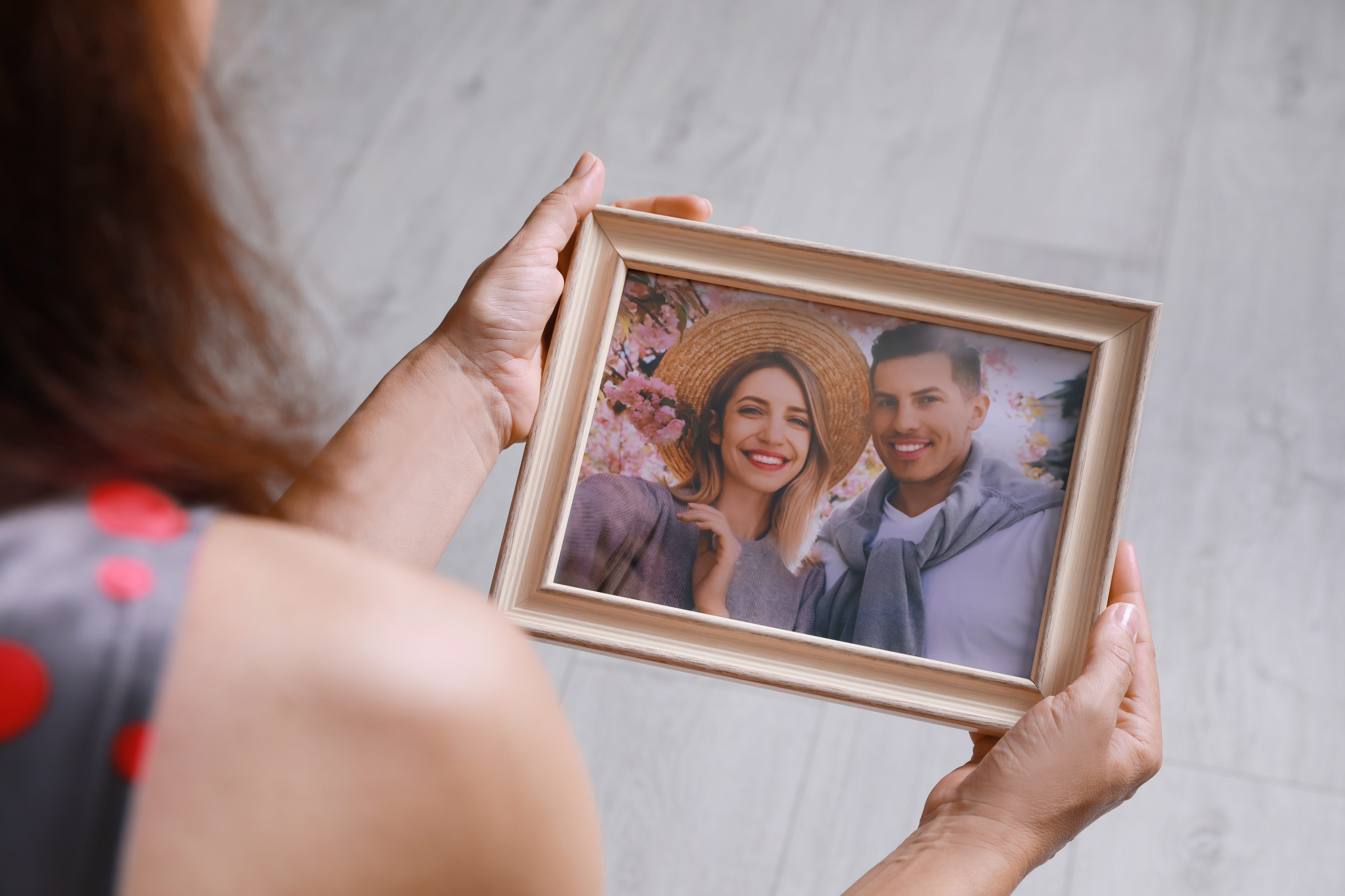 Woman holding framed photo. | Source: Shutterstock