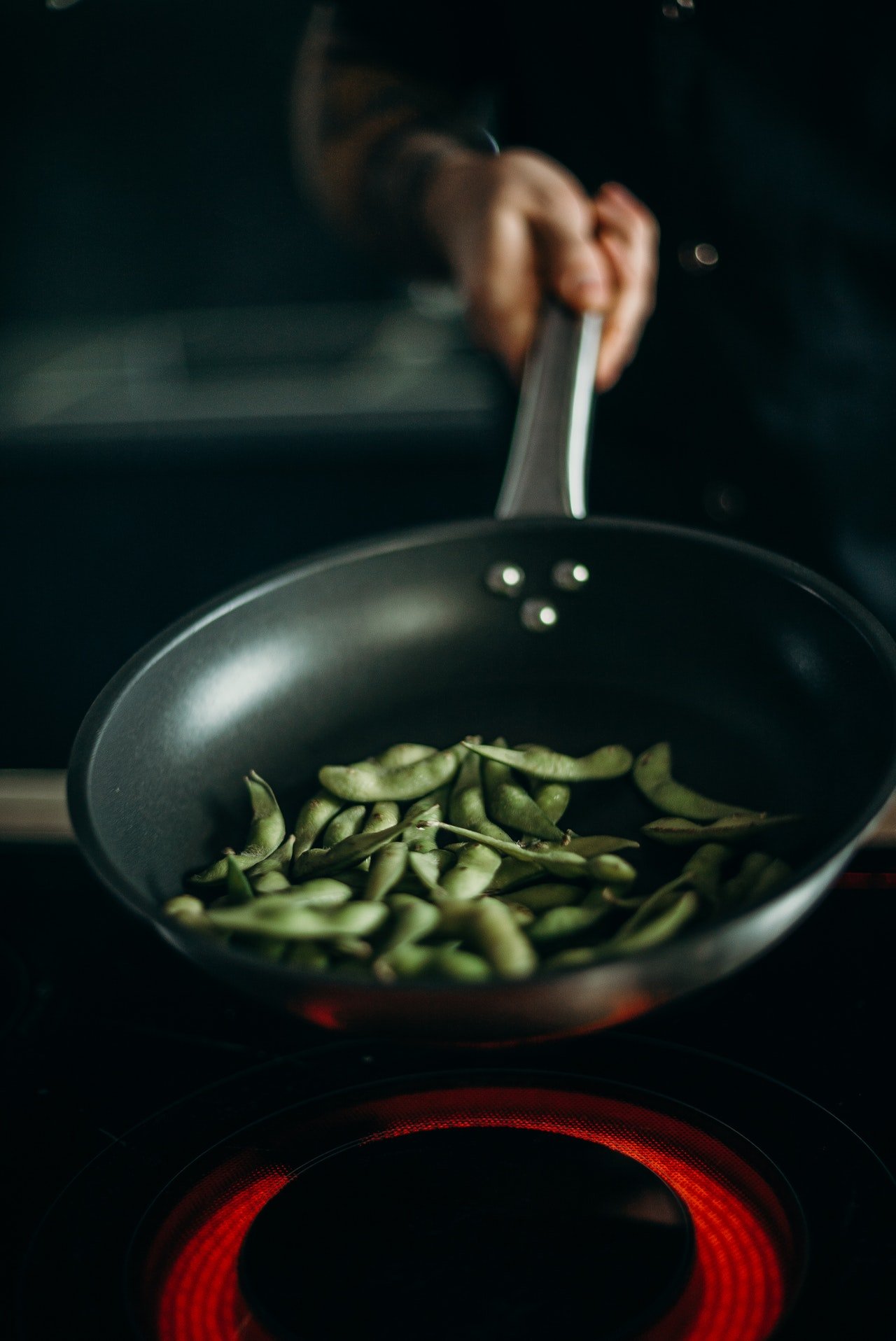 Person holding skillet with green beans | Source: Pexels