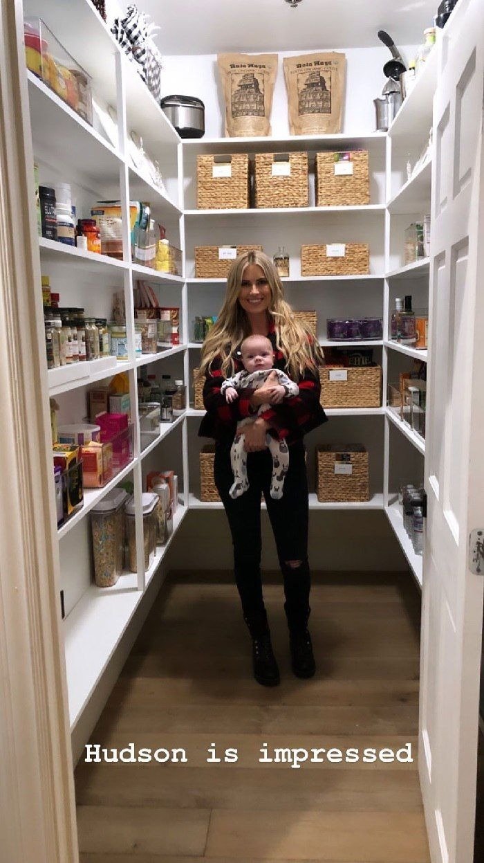 Christina Anstead poses in her professionally organize pantry with her son, Hudson London Anstead | Source: Instagram.com/christinaanstead