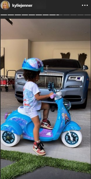 Stormi Webster wearing an helmet on a blue bike | Photo: Instagram/kyliejenner