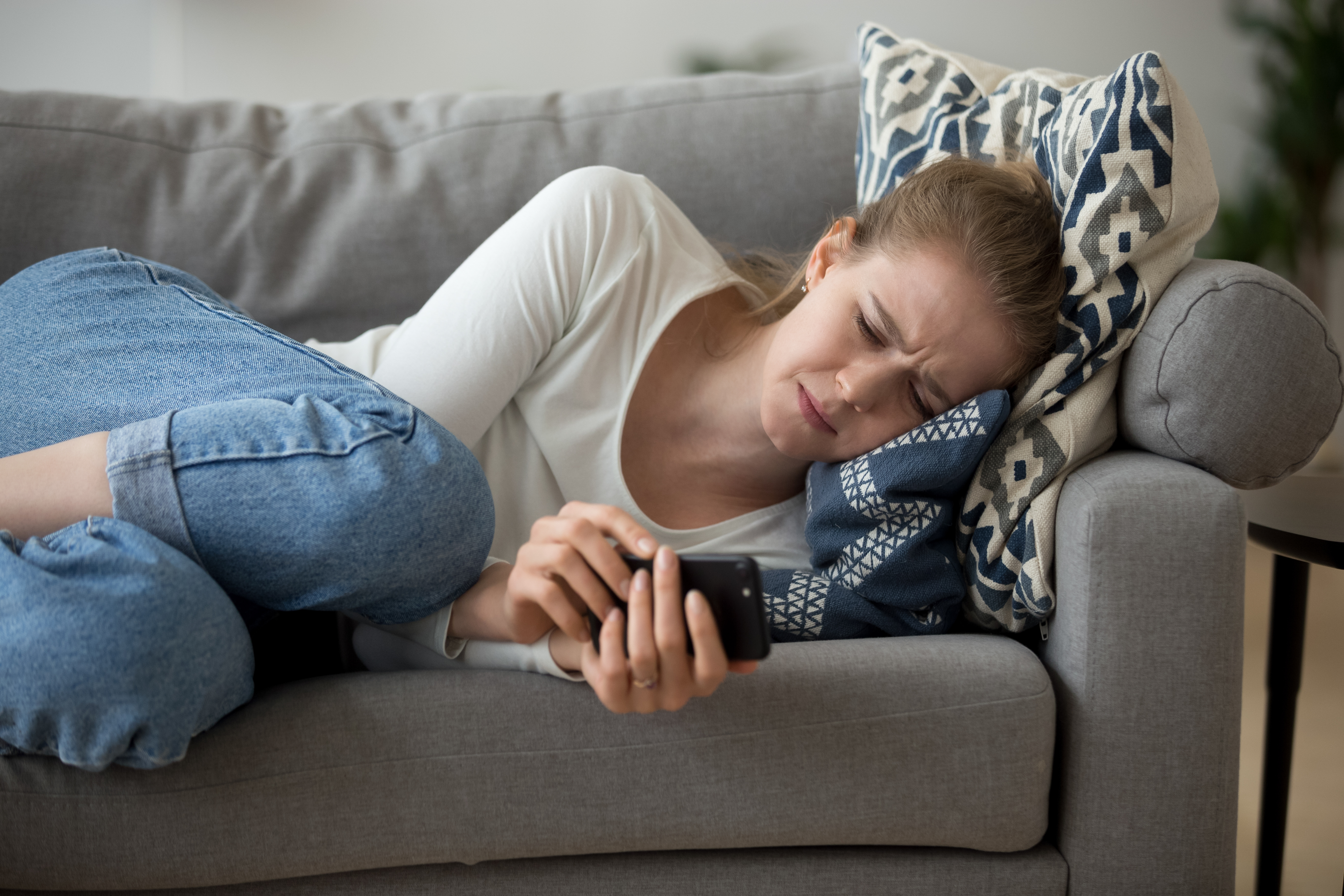 A young girl crying while lying on the couch | Source: Shutterstock