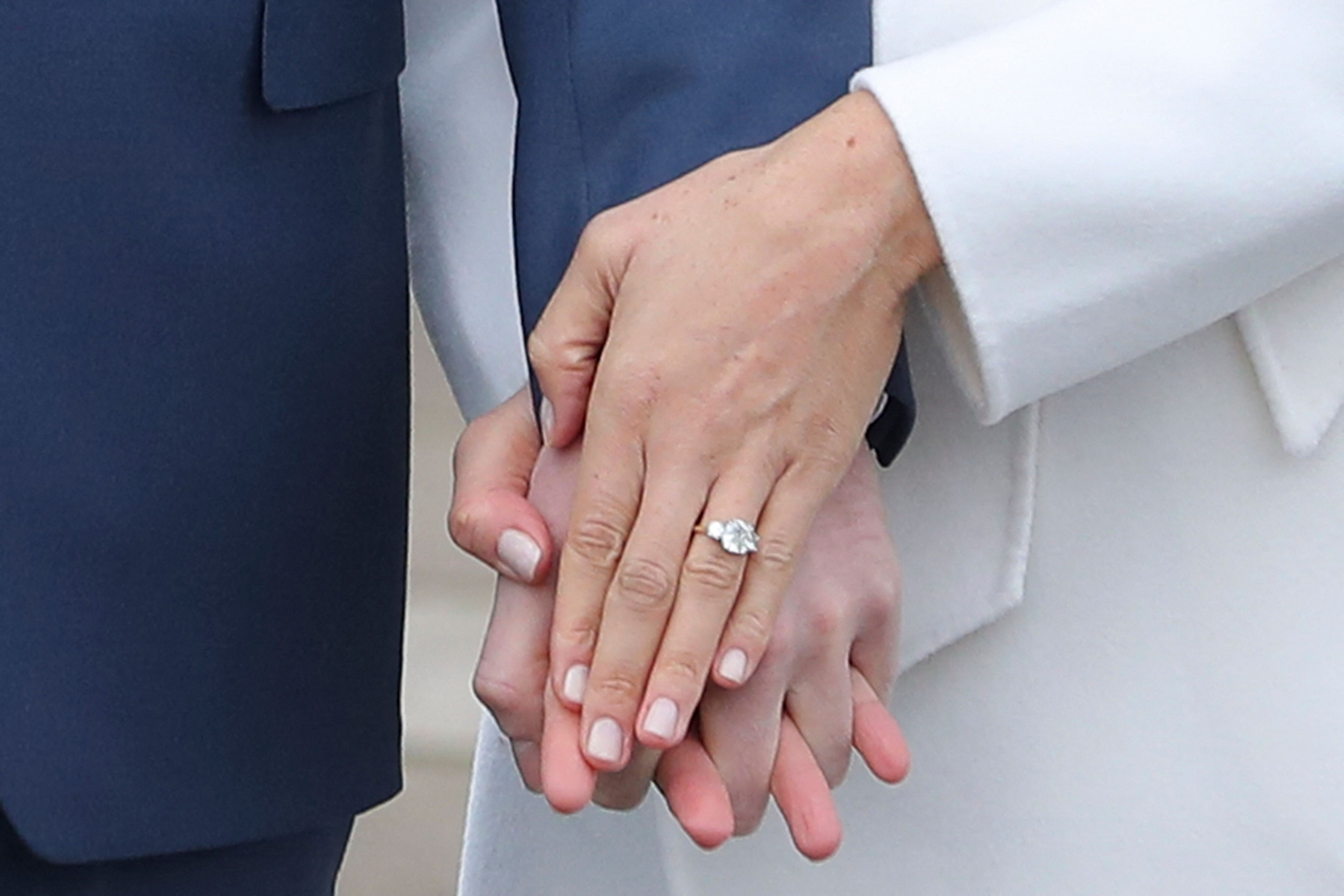 A close up picture of Prince Harry and Meghan Markle's hands with her engagement ring showing. | Source: Getty Images