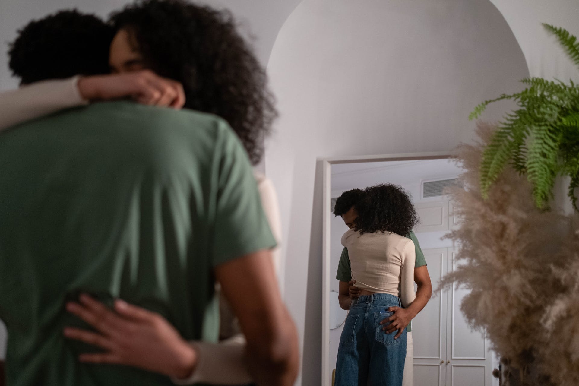 A couple hugging in front of a mirror | Source: Pexels