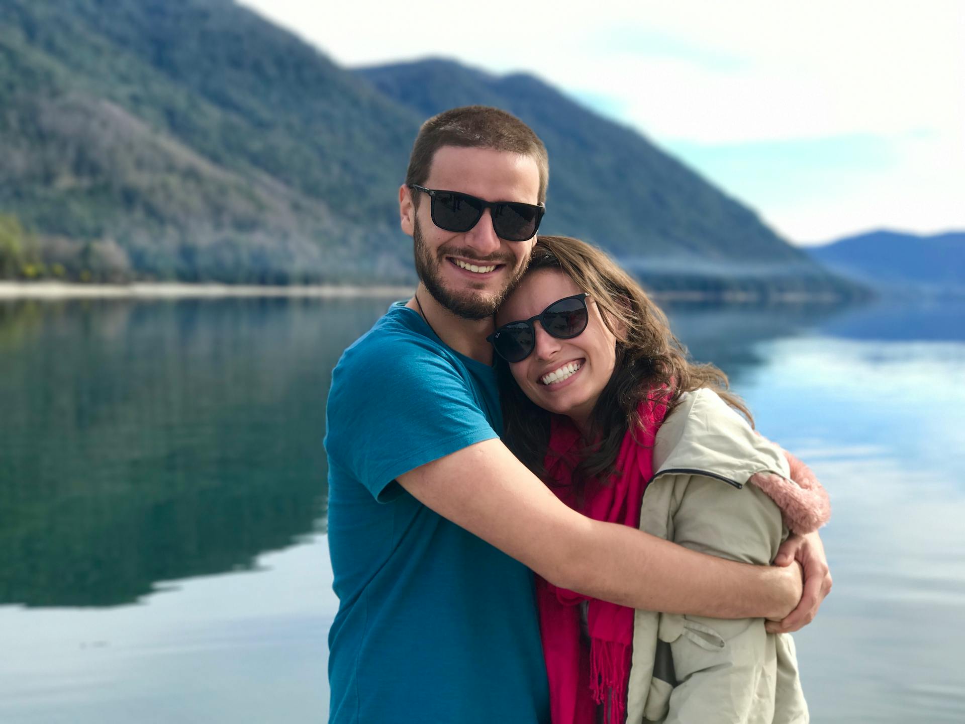 A happy couple hug while standing near a lake | Source: Pexels